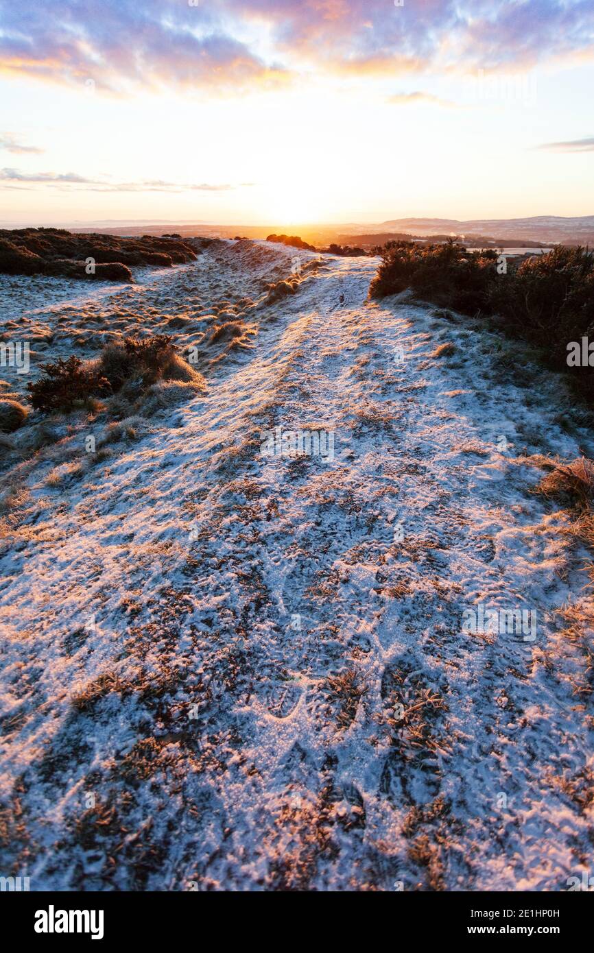 Flintshire, North Wales, UK 7th January 2021, UK Weather:  Freezing overnight temperatures have left many waking to well below zero temperatures this morning, with a sever frost in many places including North Wales. Spectacualar frozen landscape at sunrise on the ancient iron age hillfort of Moel y Gaer near Halkyn in Flintshire © DGDImages/Alamy Live News Stock Photo