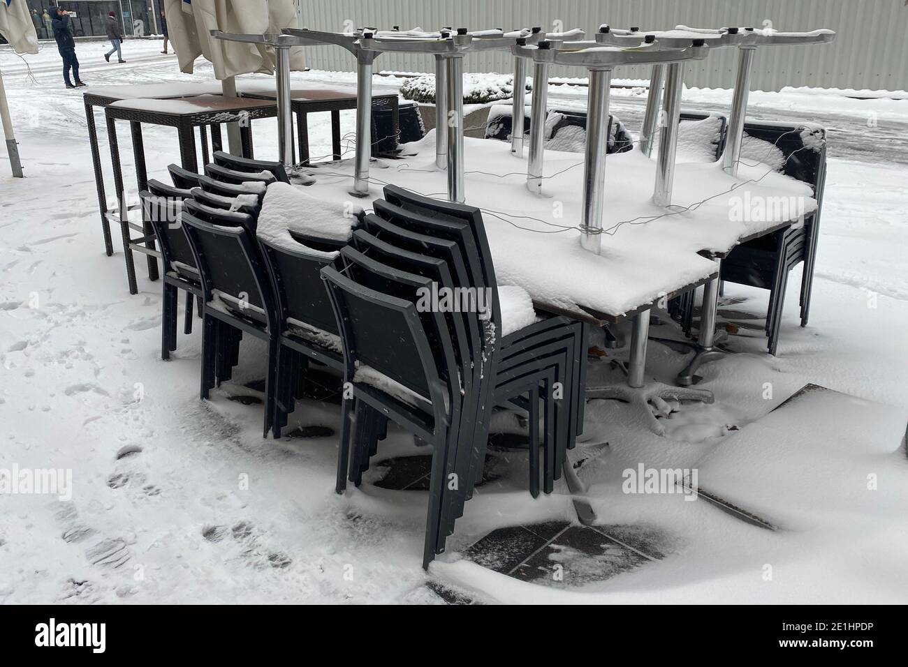 Topic picture: Winter in times of the coronavirus pandemic/extension of lockdown until January 31, 2021. Consequences for gastronomy Snow lies on folded and stacked tables and chairs in the outside area of a closed restaurant in Munich on January 6th, 2021. Outside gastronomy. | usage worldwide Stock Photo
