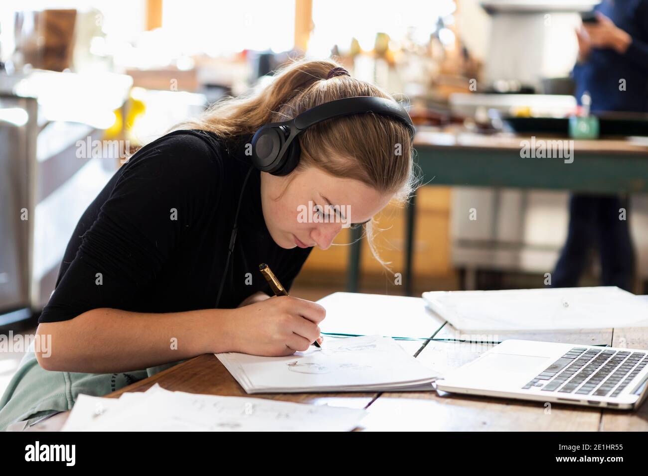 teenage girl wearing headphones, drawing on paper Stock Photo