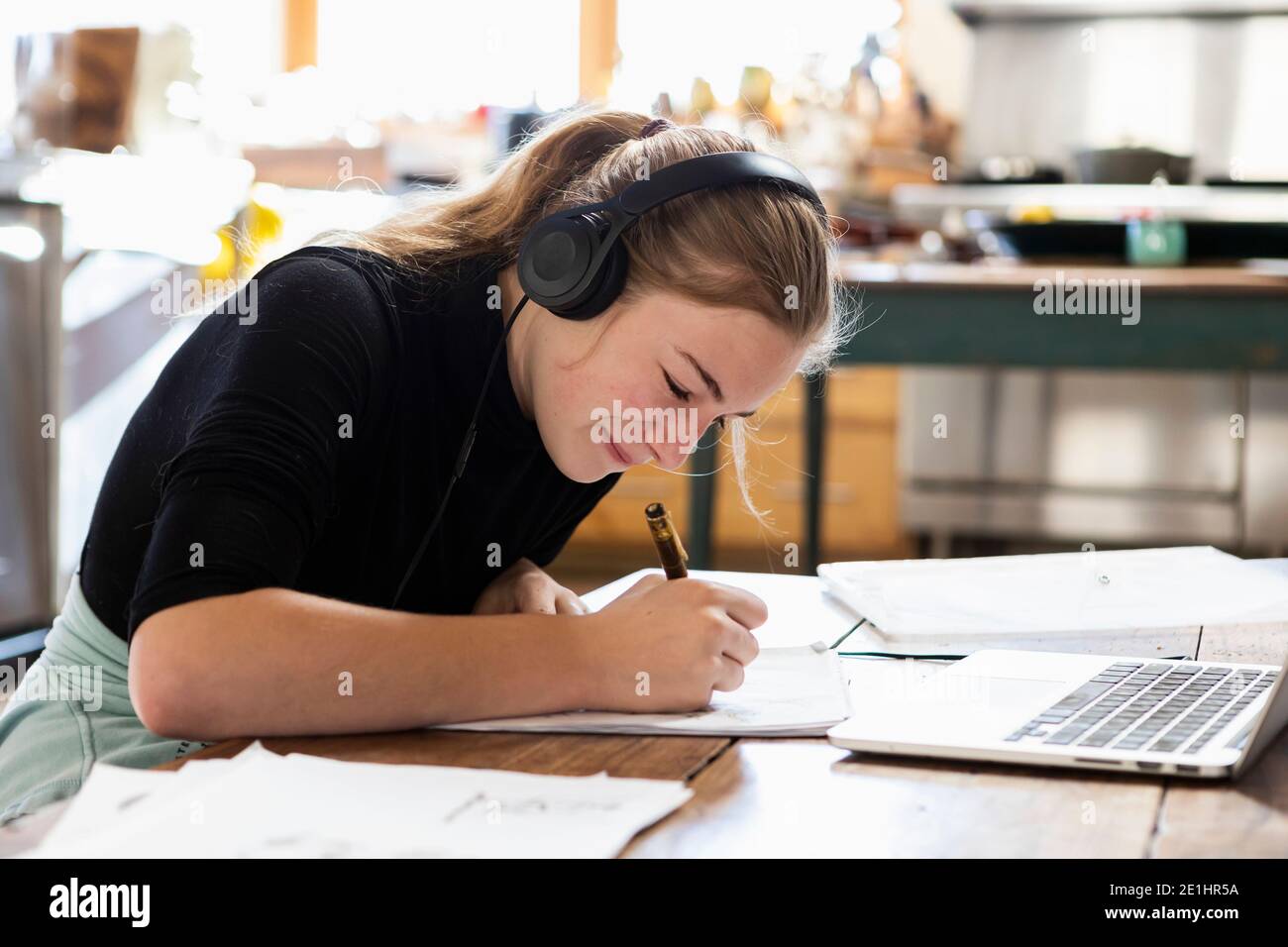 teenage girl wearing headphones, drawing on paper Stock Photo