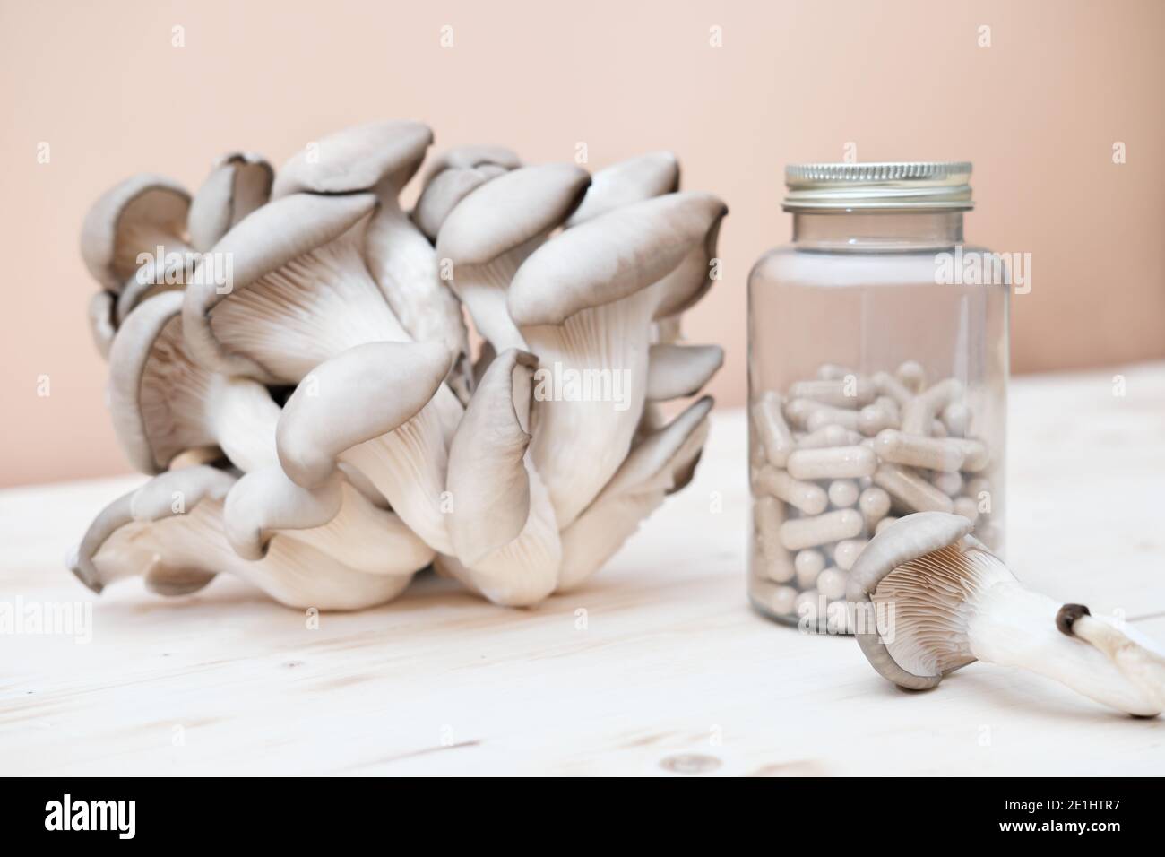 a bottle of mushroom supplement capsules and fresh mushrooms on a