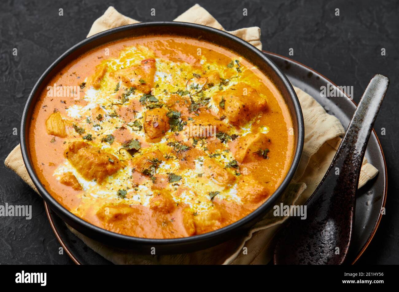 Murgh Makhani or Butter Chicken in black bowl on dark slate table top