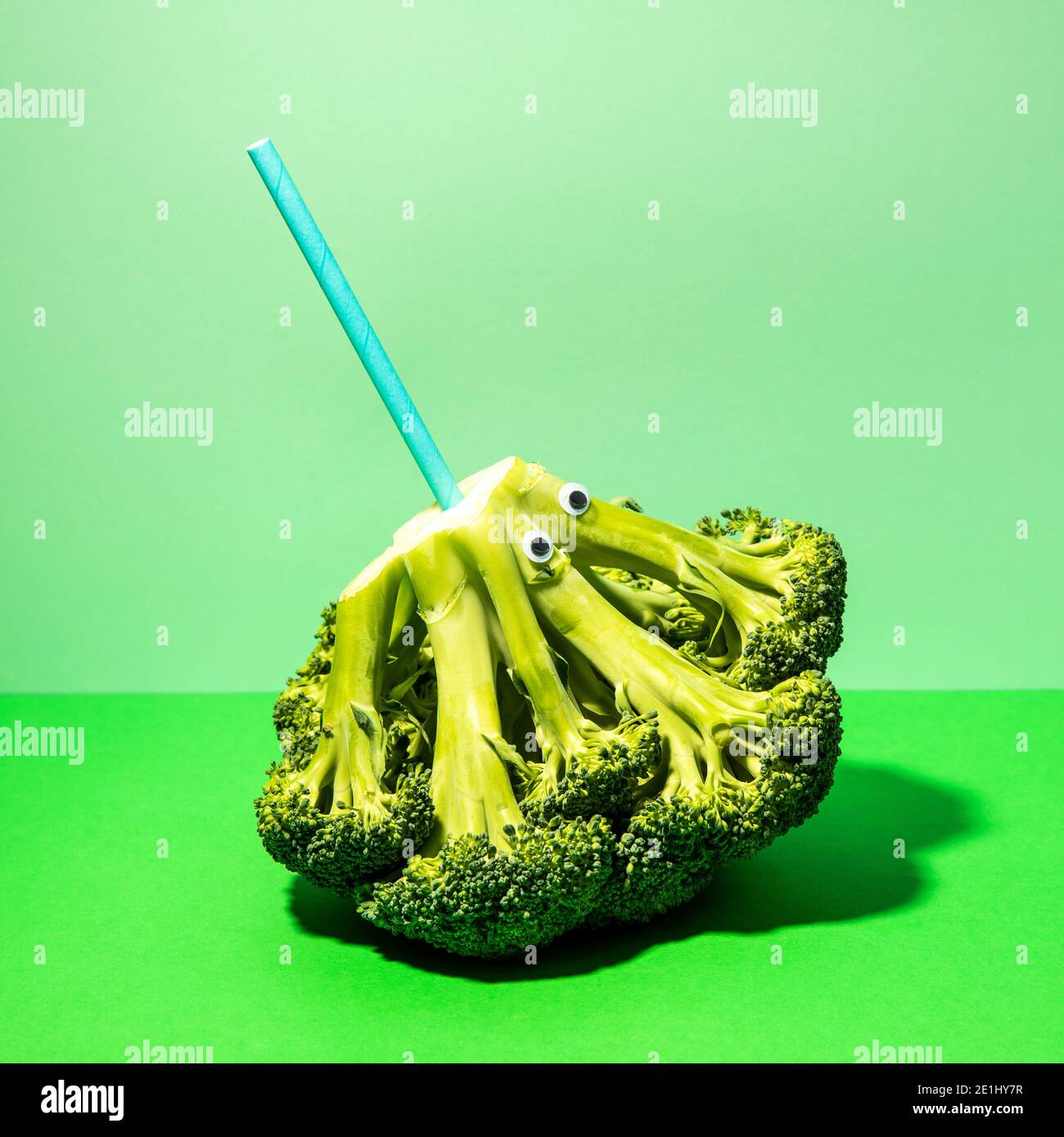 Fun broccoli with eyes and a straw. Stock Photo