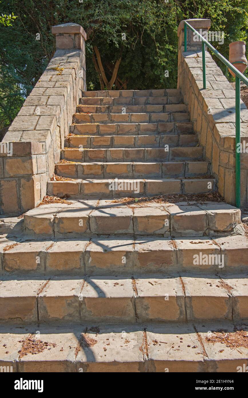 Closeup detail of stone paved steps on rural footpath walkway going upwards in formal garden grounds Stock Photo