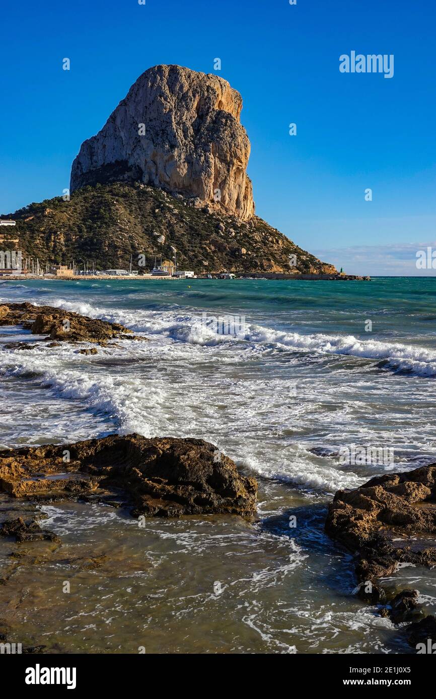 Surf waves and The Penon d'Ifach, at the popular holiday destination of Calpe, on the Costa Blanca, Alicante, Spain Stock Photo