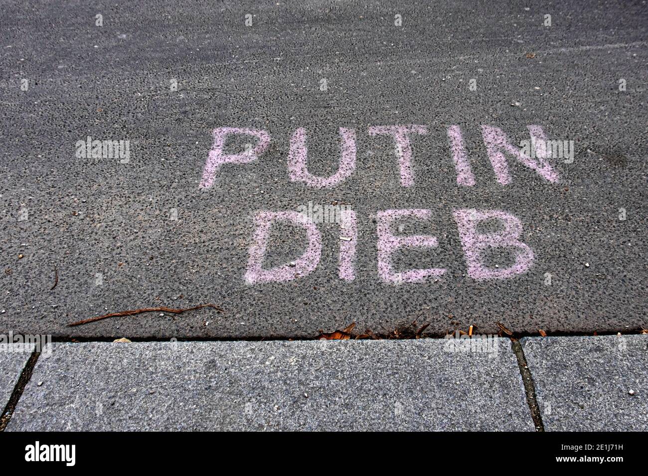 Putin Dieb, Putin thief, pink graffiti message on tar road in Mitte,Berlin,Germany Stock Photo
