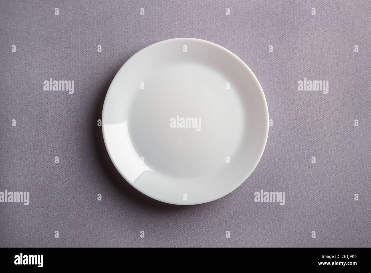 White plate on a gray background. View from above Stock Photo