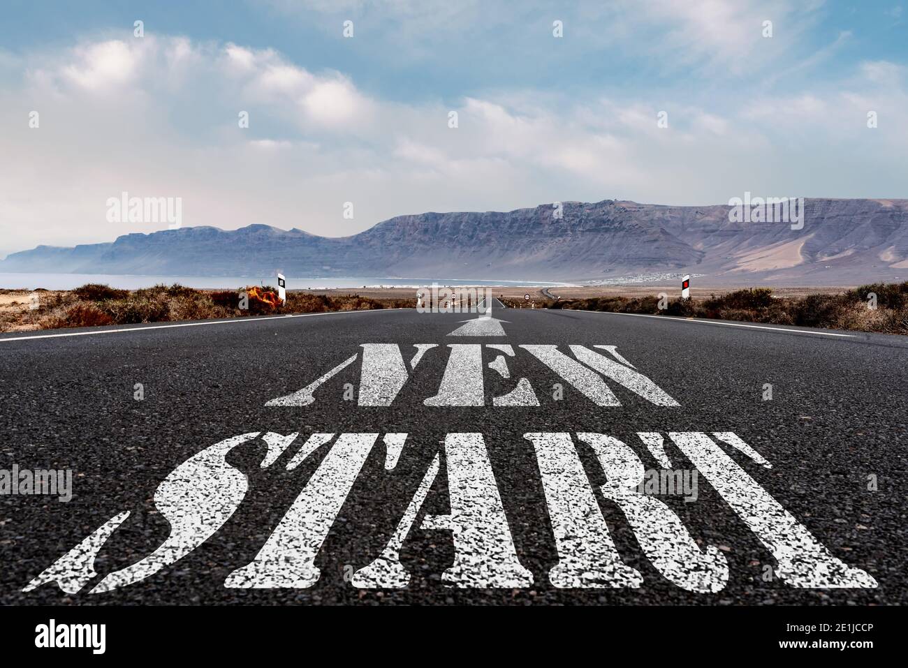 low angle view of words NEW START and arrow symbol painted on asphalt road, new beginning and restart concept Stock Photo