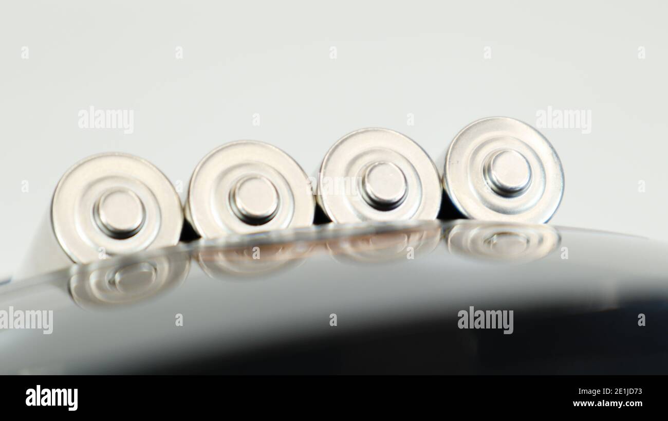 Rechargeable alkaline batteries in a battery charger on a white