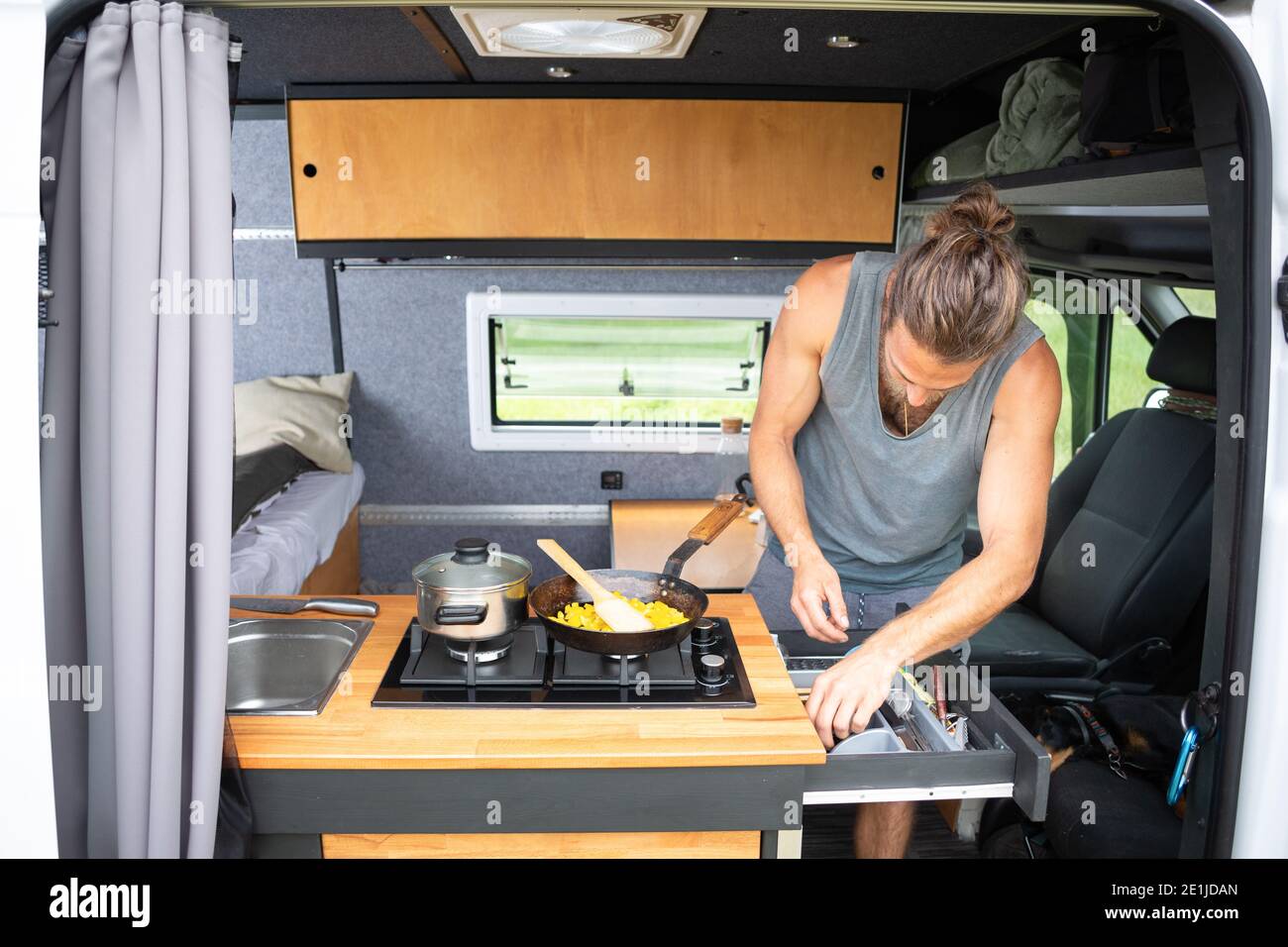 Man using the kitchen area inside his caravan Stock Photo