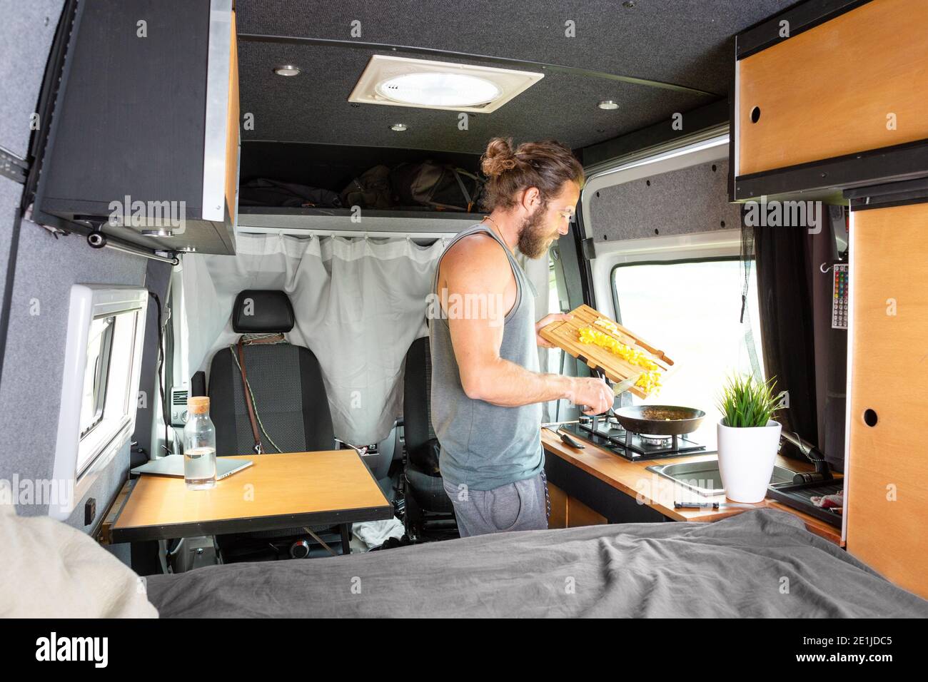 Man inside his camper van is preparing food Stock Photo