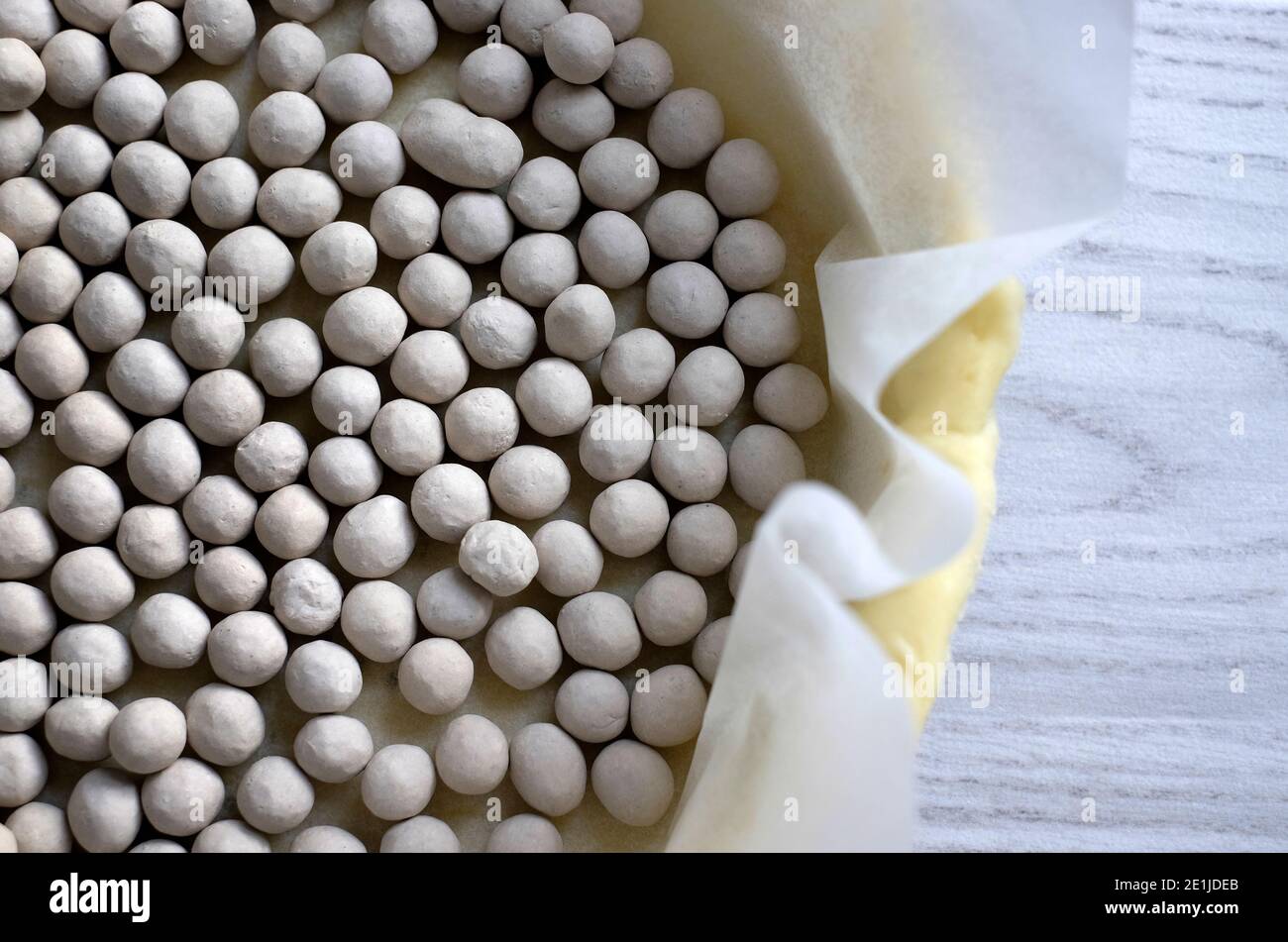 baking beans on pastry base on greaseproof paper on tray Stock Photo