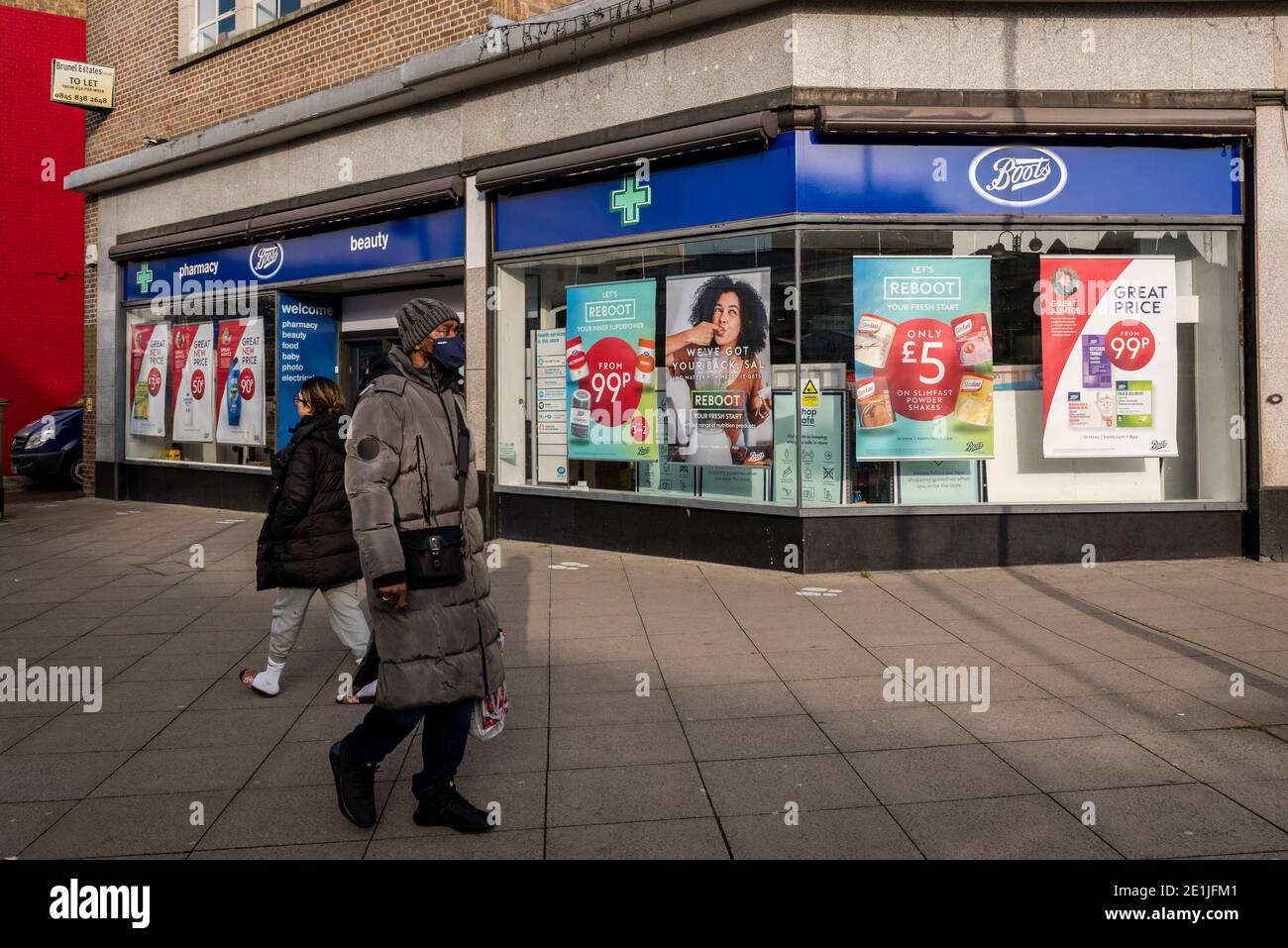 Uxbridge, UK. 7 January 2021. People pass a Boots pharmacy in Uxbridge,  north west London, on the morning that the third national lockdown came in  to effect. It is reported that some