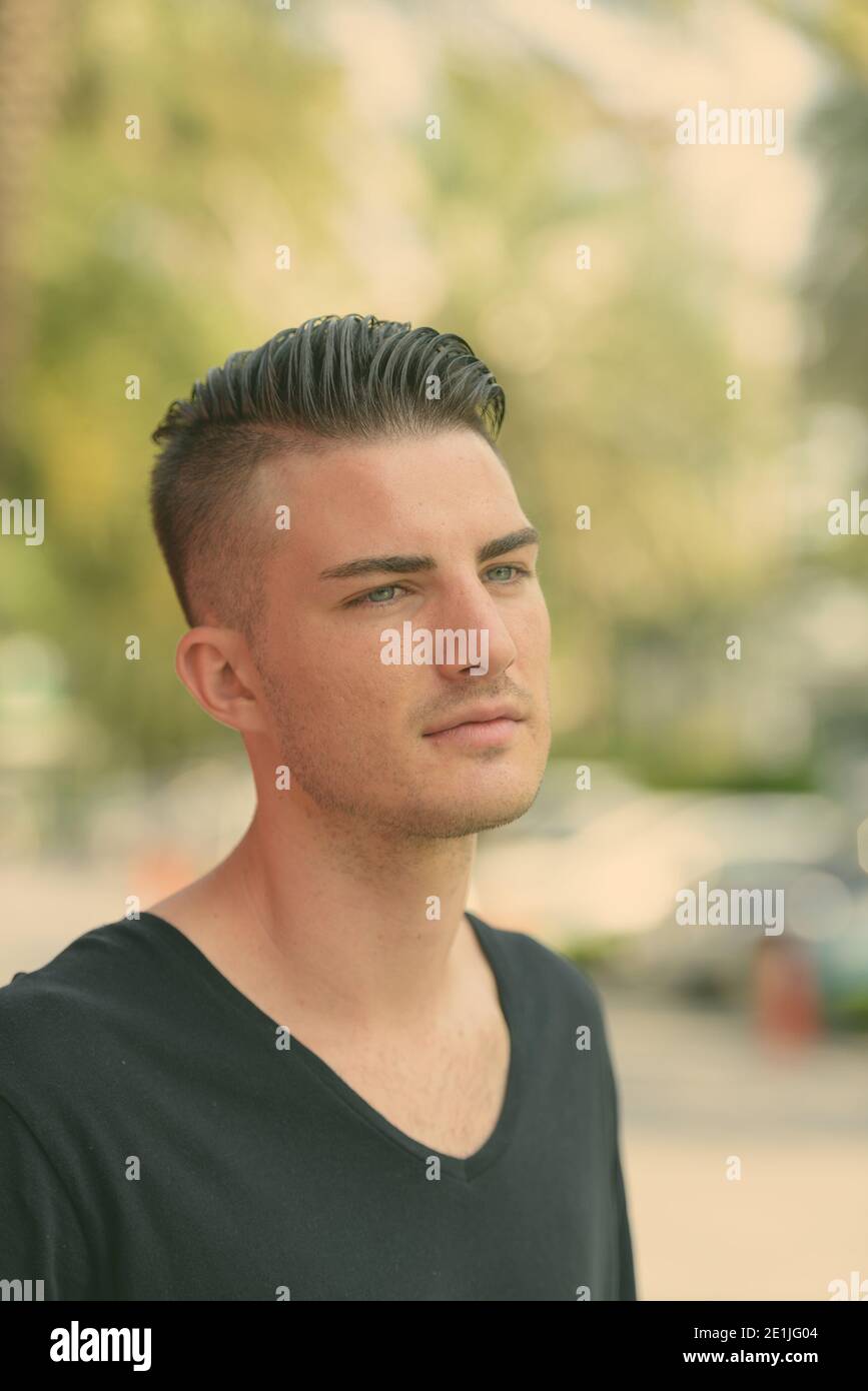 Young handsome man thinking while looking at distance in the parking lot Stock Photo