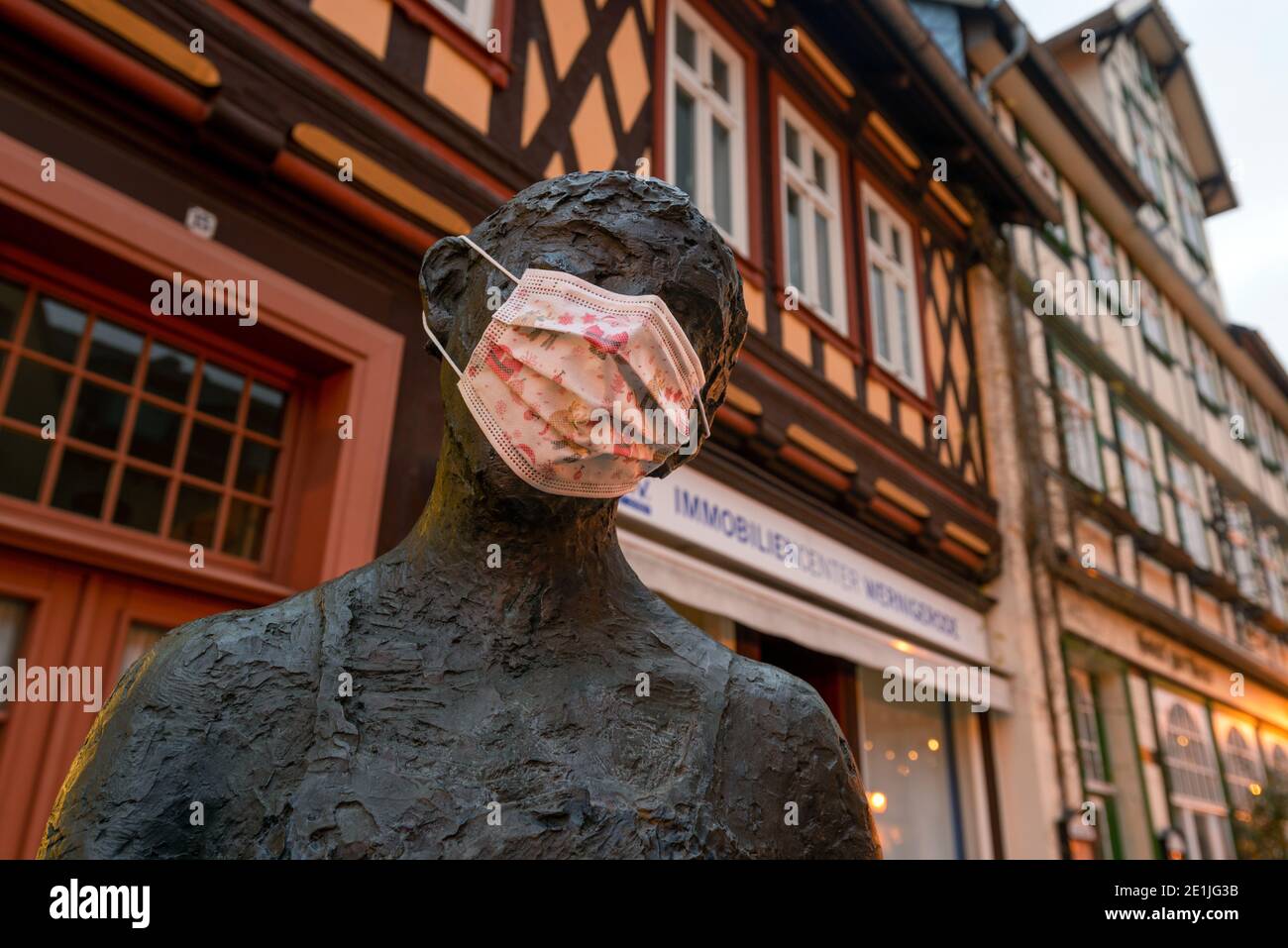 Wernigerode, Germany. 26th Dec, 2020. Someone has put a mask on a bronze figure in the historic old town. Normally, tourists from Germany and abroad visit the half-timbered town of Wernigerode am Harz over the holidays. This year, however, the hotels and streets remain empty because of the Corona pandemic. Credit: Stephan Schulz/dpa-Zentralbild/ZB/dpa/Alamy Live News Stock Photo