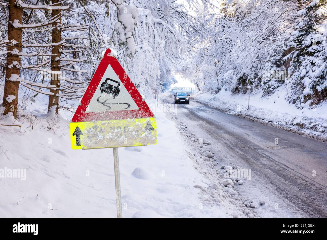 Strassenschild warnt vor Schneeglätte und Eis im Winter Stock Photo