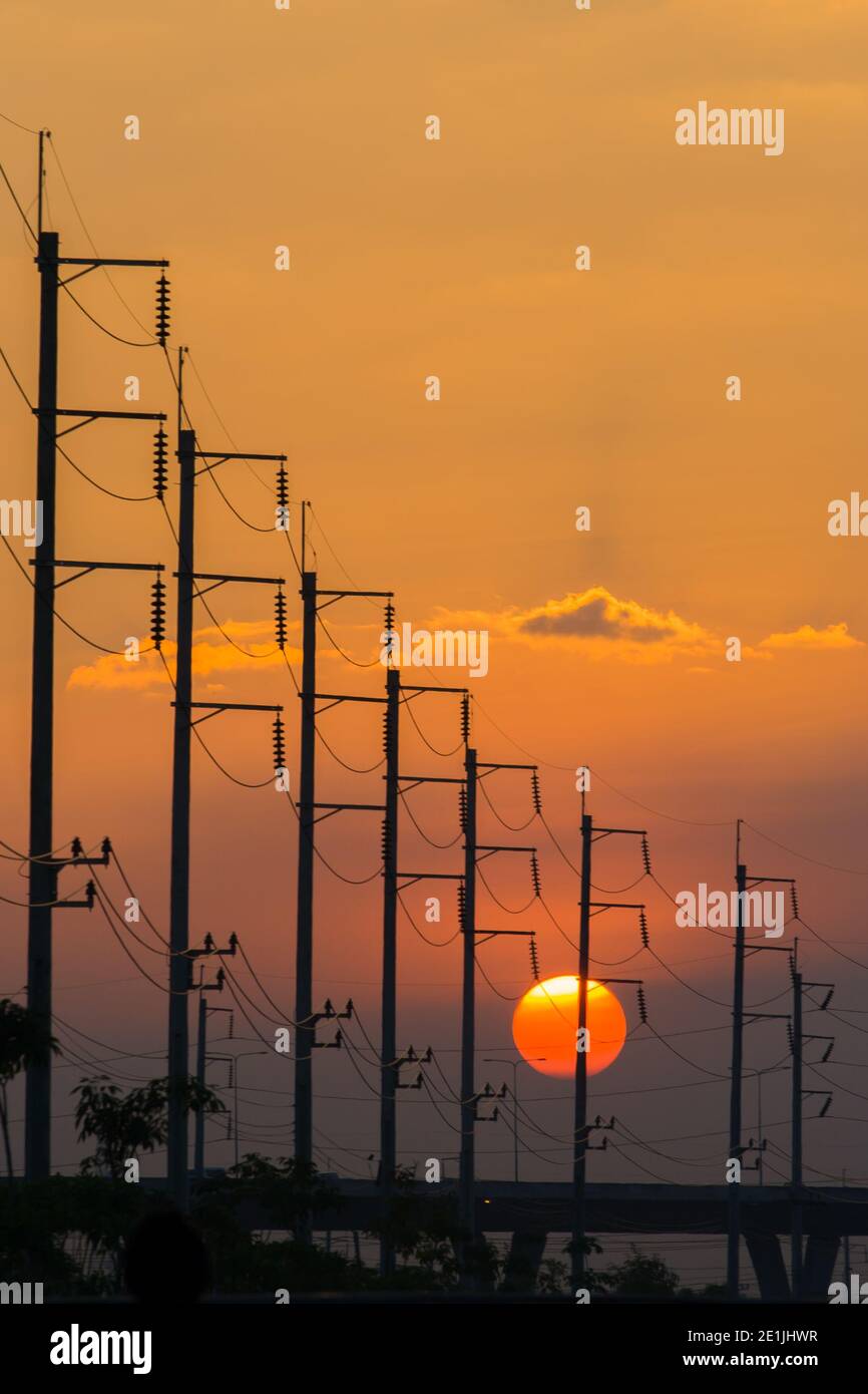 Electricity post in front of sunset background Stock Photo - Alamy