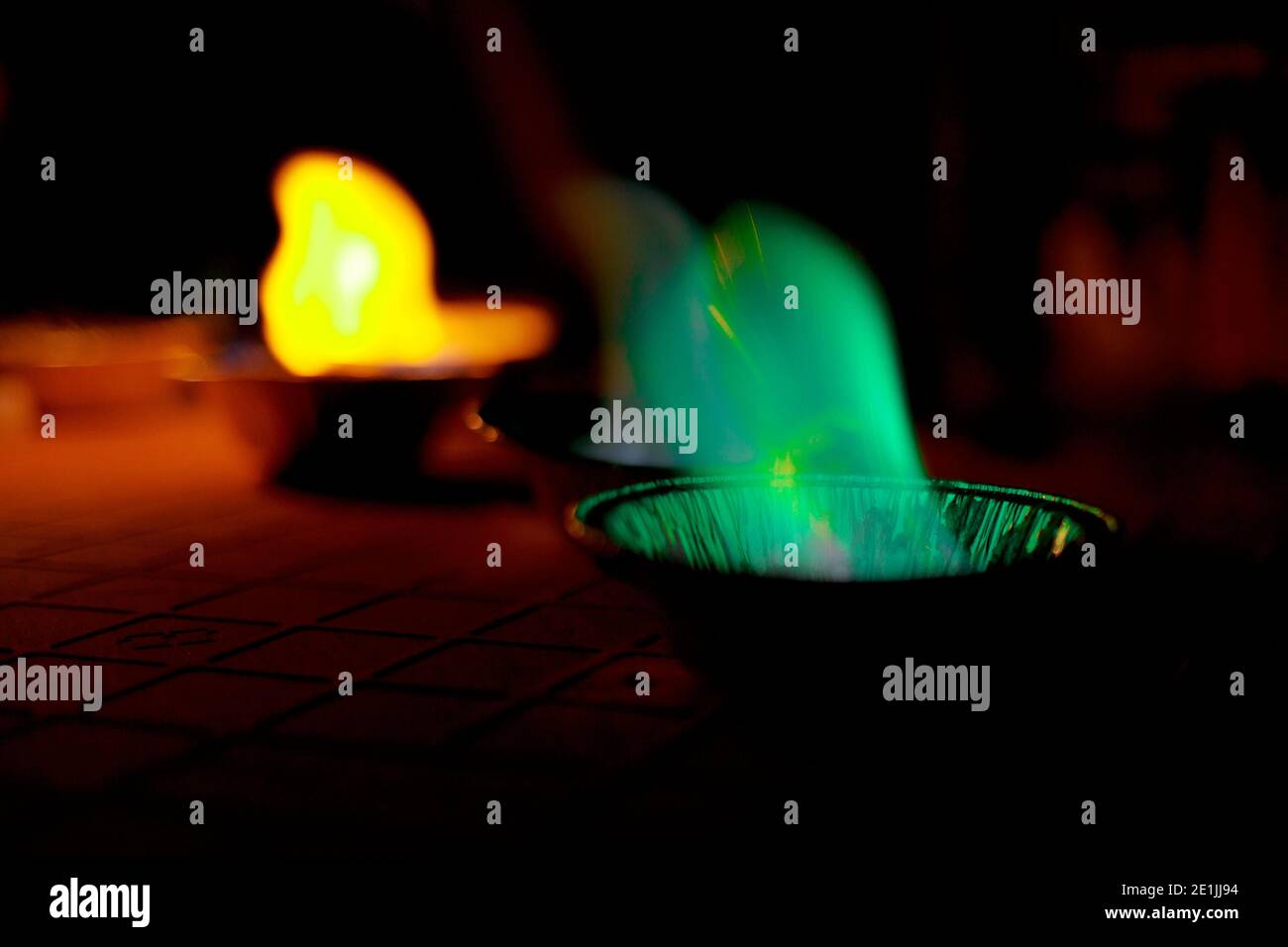 chemical experiment with fire. multi-colored flames in the dark. Stock Photo