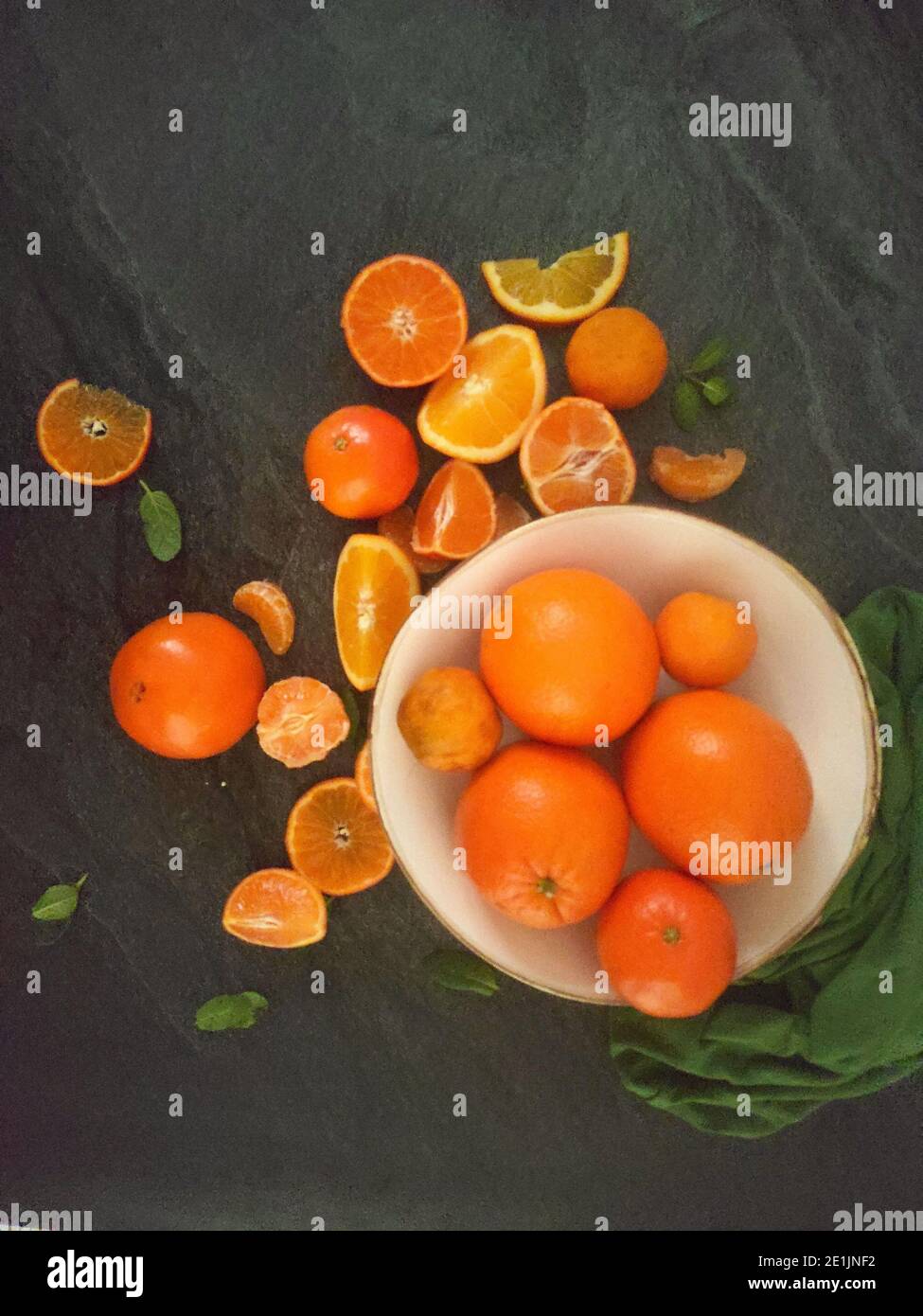 Whole and sliced oranges on a luxury dark background under the sunlight Stock Photo