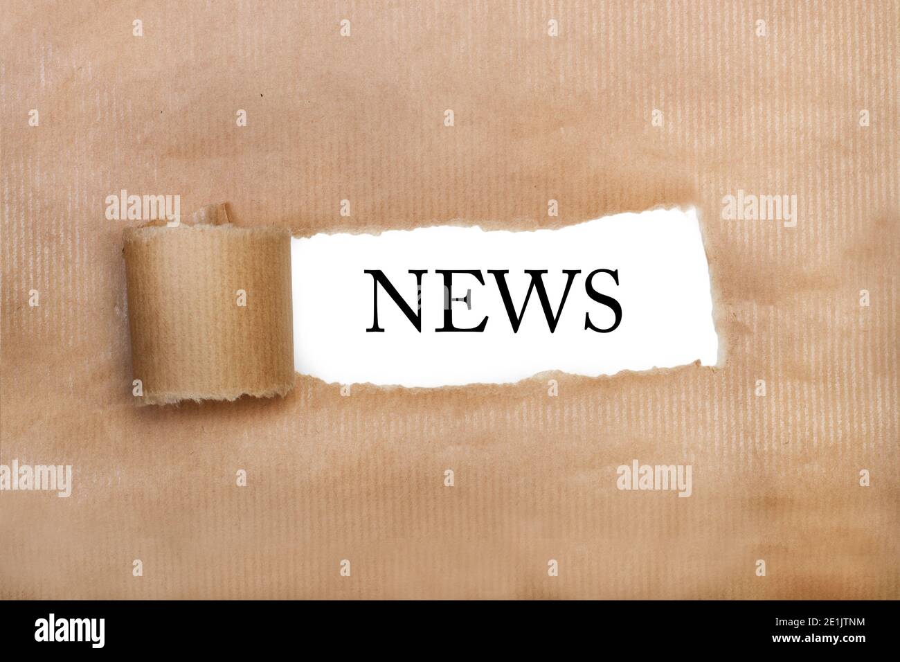 A tear brown paper with news word write in it Stock Photo
