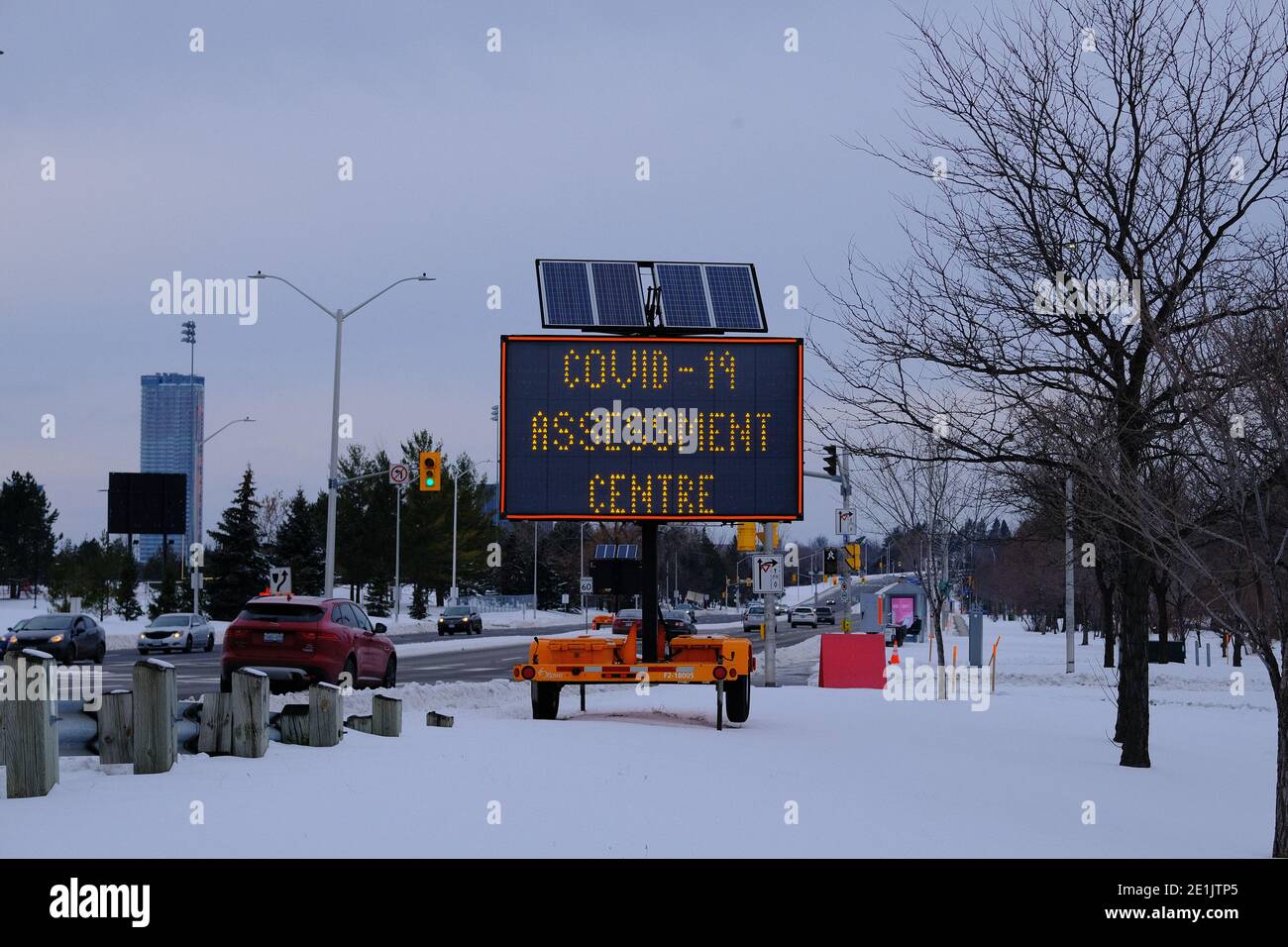 COVID-19 temporary road sign in the snow on Bronson Avenue directing people to the Brewer Park Arena testing site, Ottawa, Ontario, Canada. Stock Photo