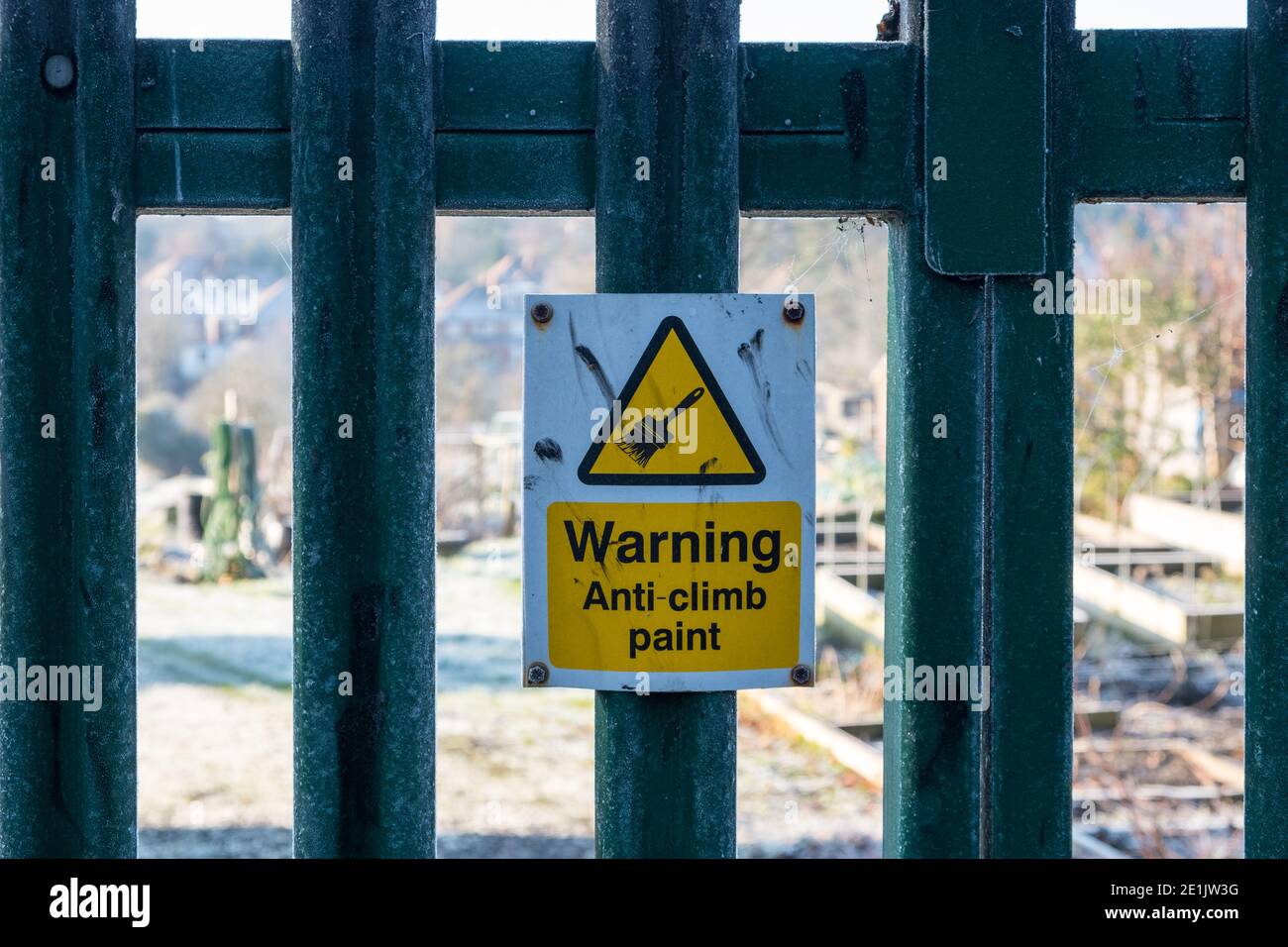 Warning sign - anti climb paint attached to metal fence Stock Photo