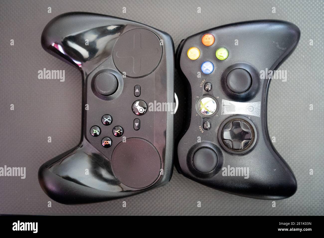 Xbox vs the steam controller on a carbon fiber background showing  technology of inputs for computer gaming Stock Photo - Alamy