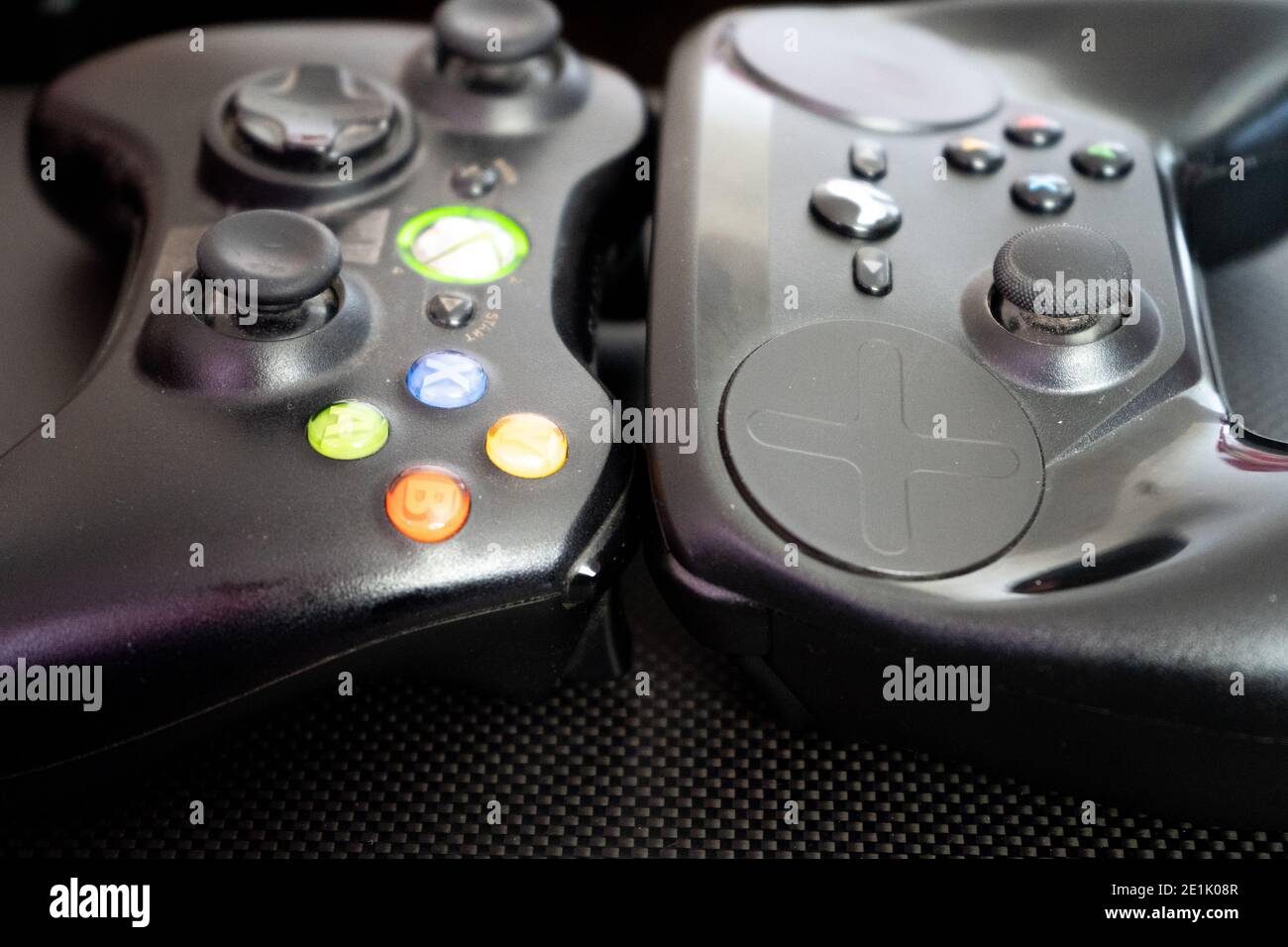 Xbox vs the steam controller on a carbon fiber background showing  technology of inputs for computer gaming Stock Photo - Alamy