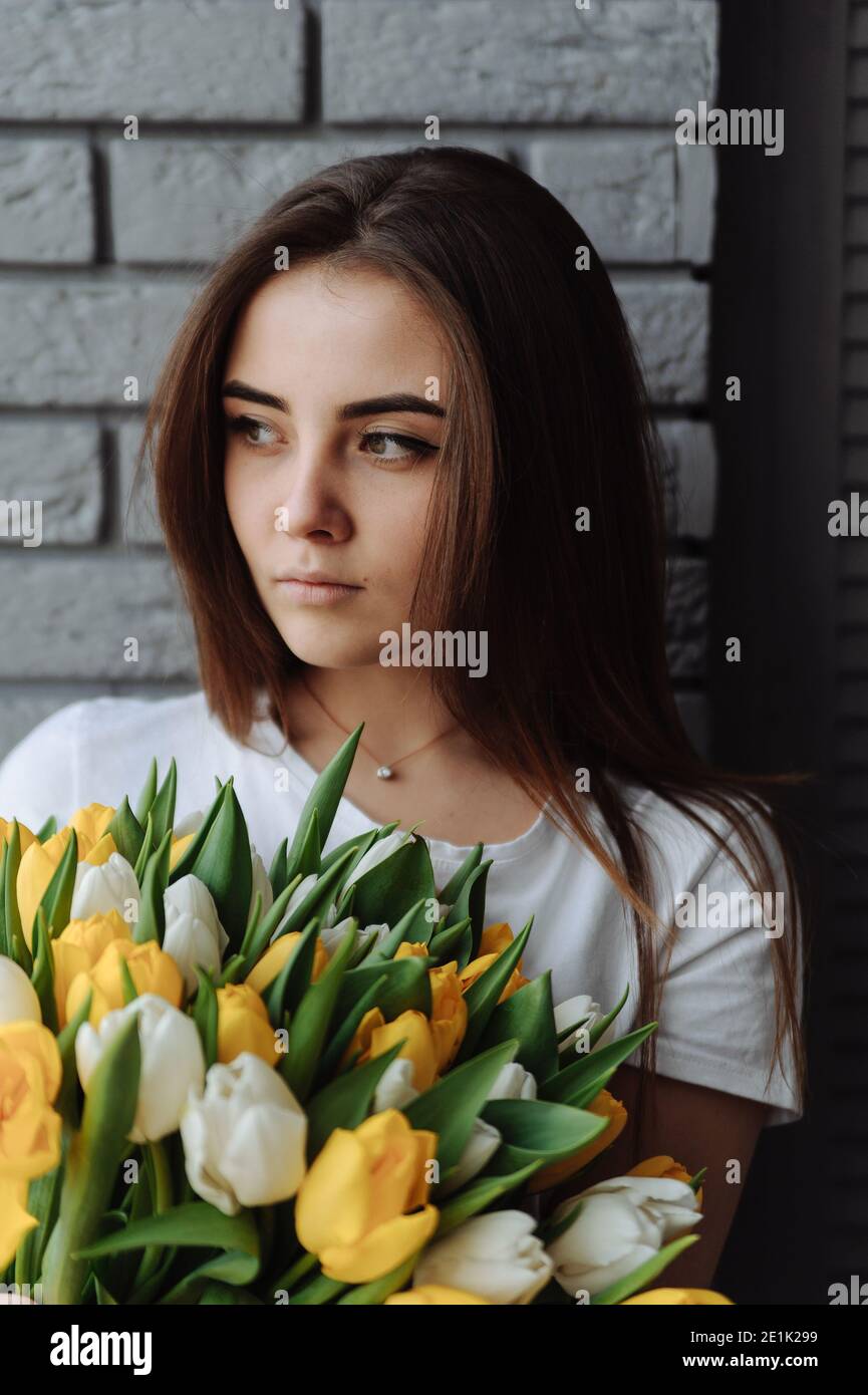 Young girl with bouquet of tulips in her hand. Woman with tulips. International women's day Stock Photo