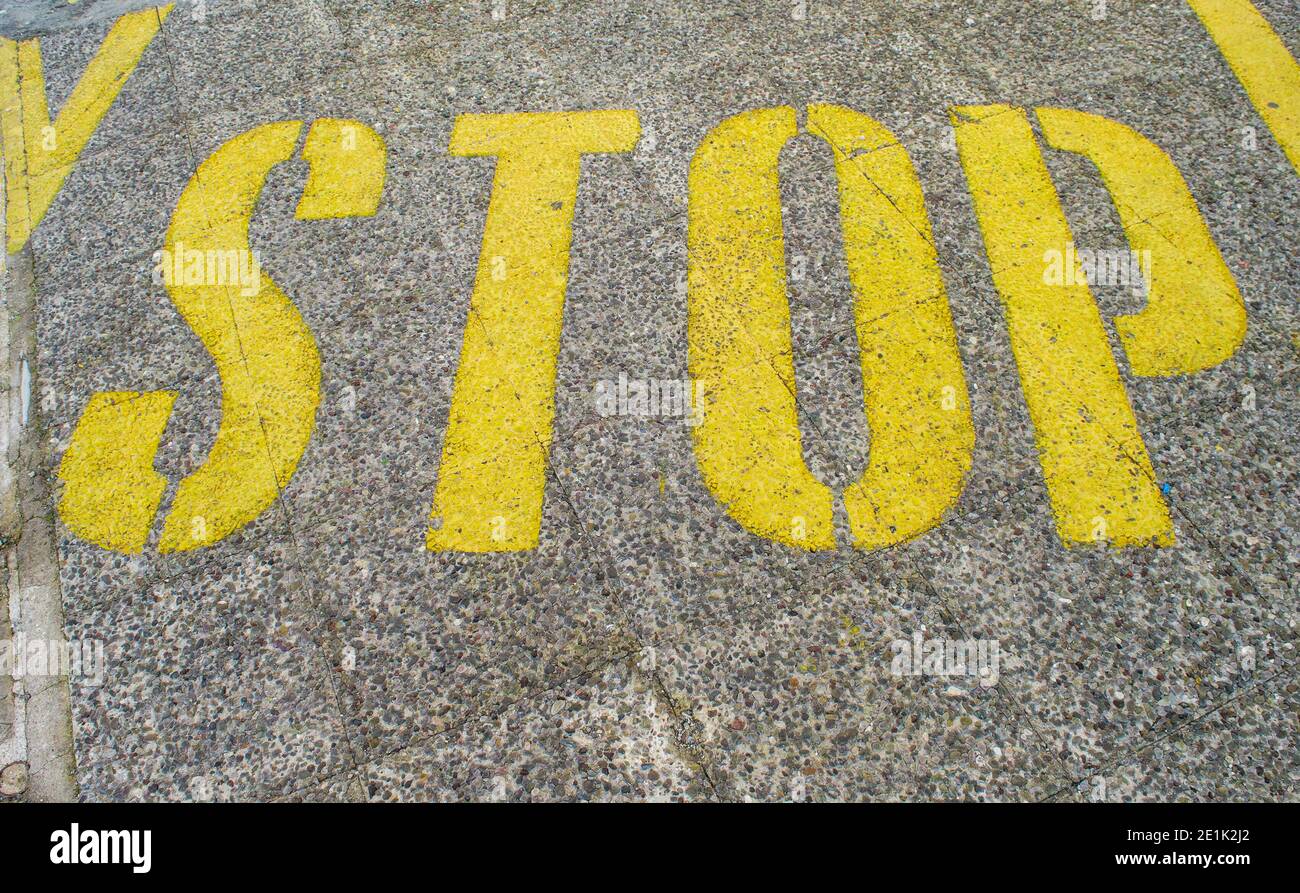 Stop sign painted on asphalt. Stock Photo