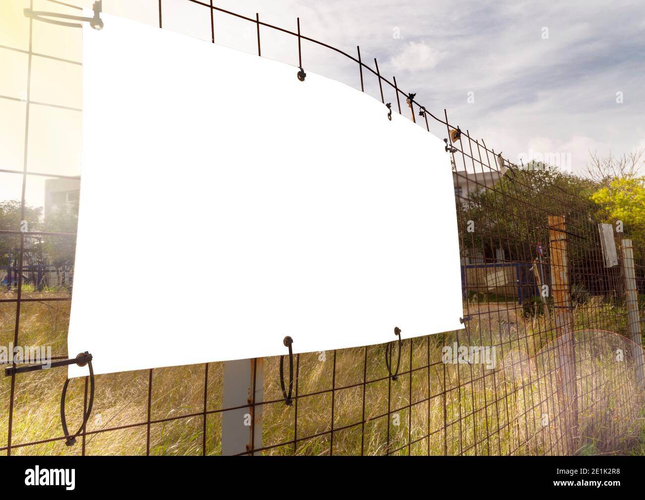 Small Format Advertisement with copy space on wire mesh by field dried grass at sunny day in Athens. Stock Photo
