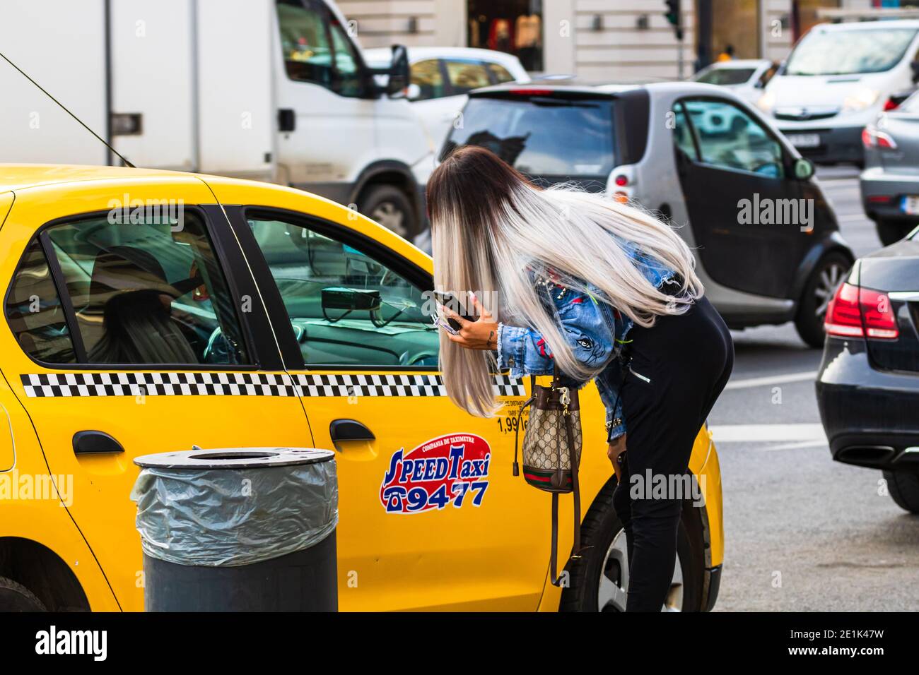 Girl asking taxi driver if available for a ride. Taxi car parked at the
