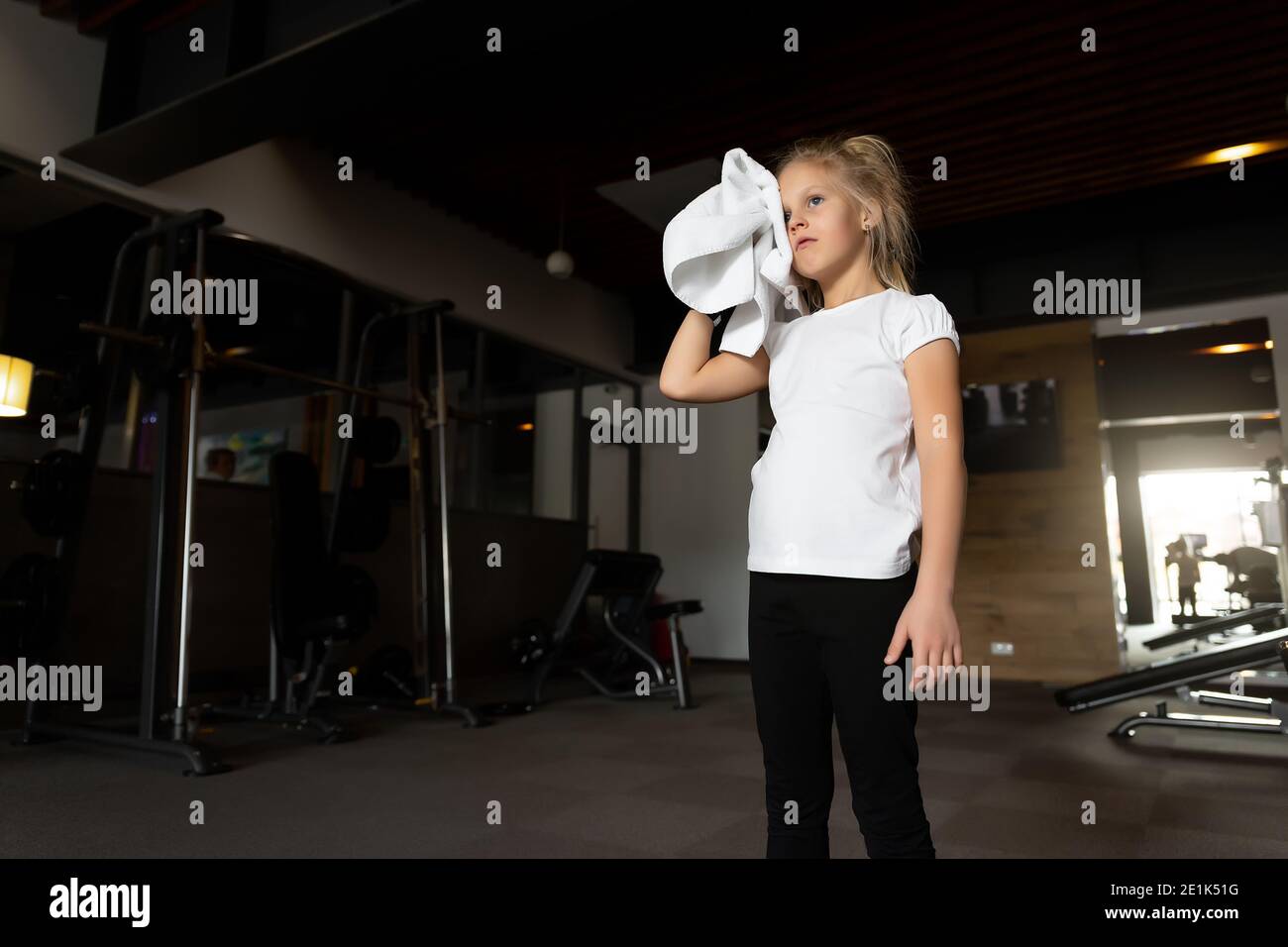 little-cute-adorable-caucasian-blond-girl-doing-finess-exercise-wiping
