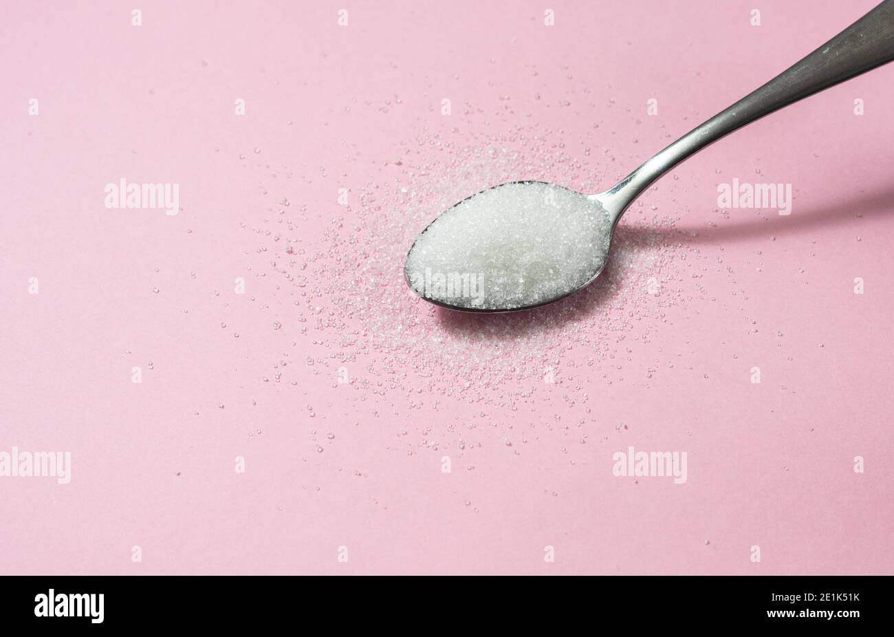 Spoon of Sugar on pink background Stock Photo