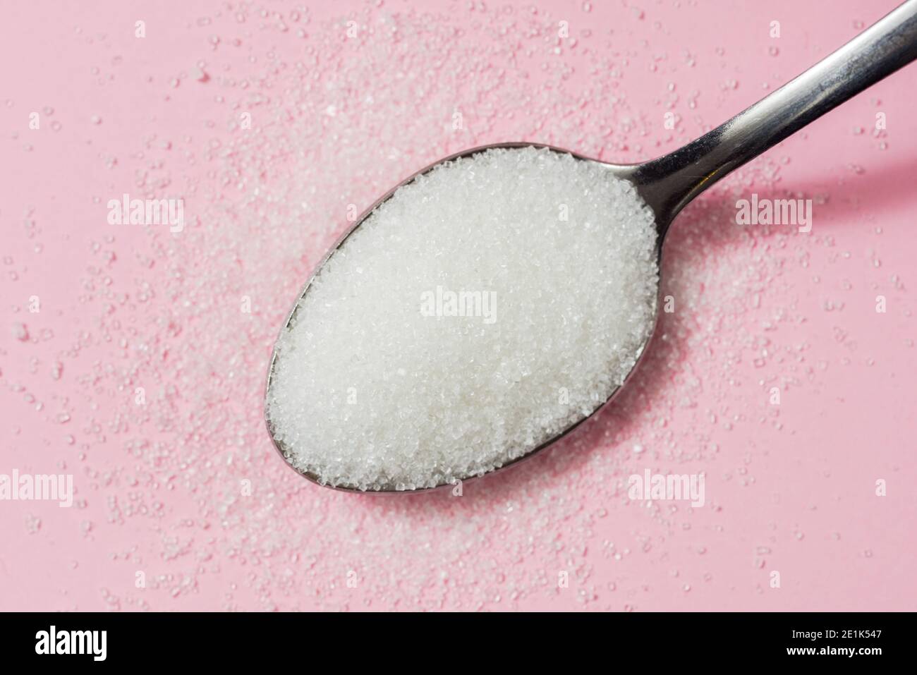 Spoon of Sugar on pink background Stock Photo