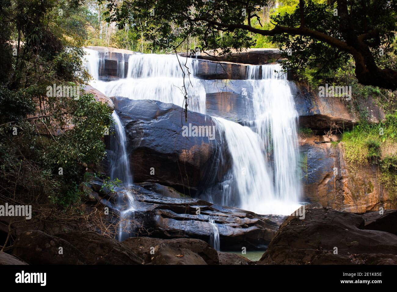 waterfall in forest with rock foreground Stock Photo - Alamy