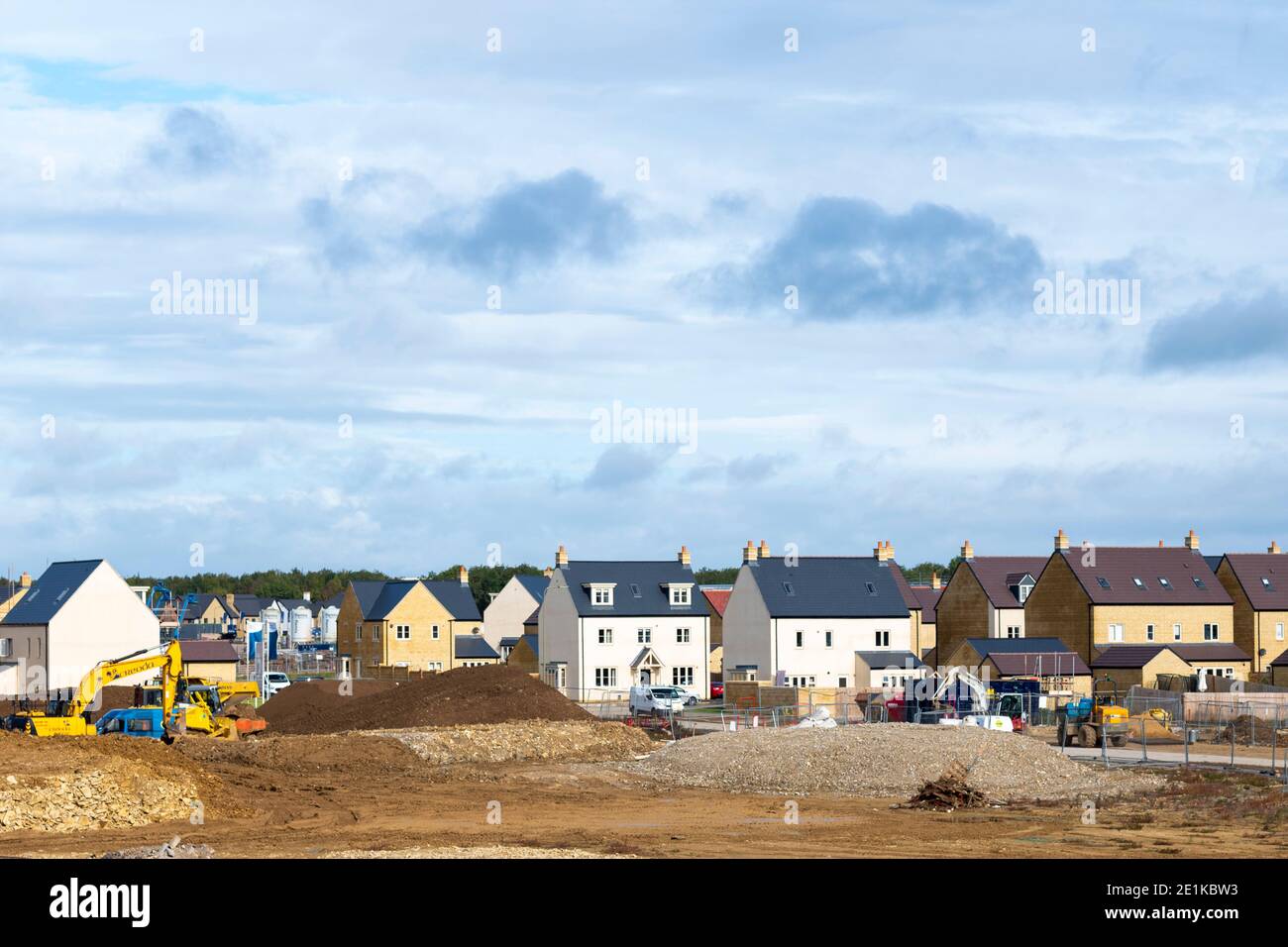 Builders working with JCB digger on a new housing development at West Witney on the outskirts of Oxford, West Oxfordshire, England due to population g Stock Photo