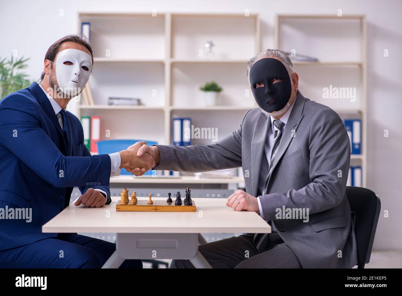 The two businessmen playing chess wearing masks Stock Photo - Alamy