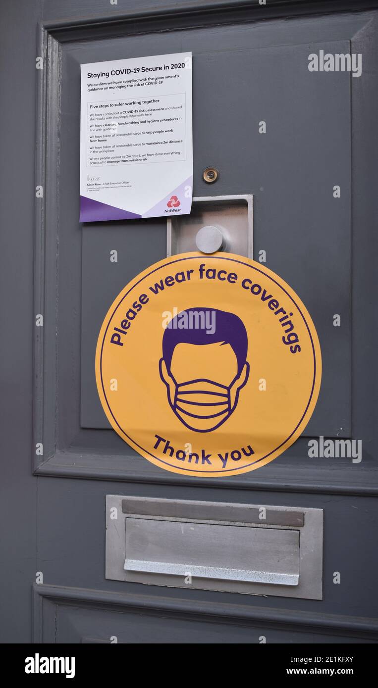 Notice on a door stating that a face covering must be worn. Stock Photo