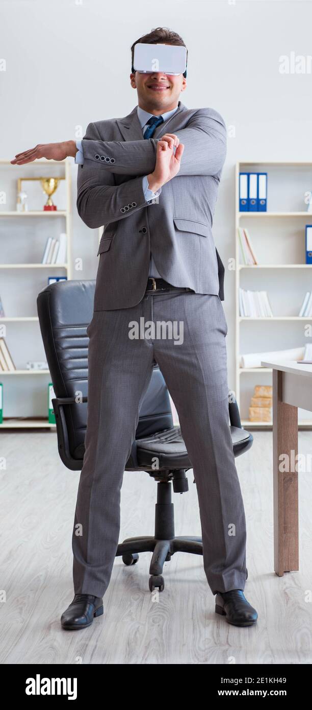 The businessman exercising in office wearing vr glasses Stock Photo - Alamy