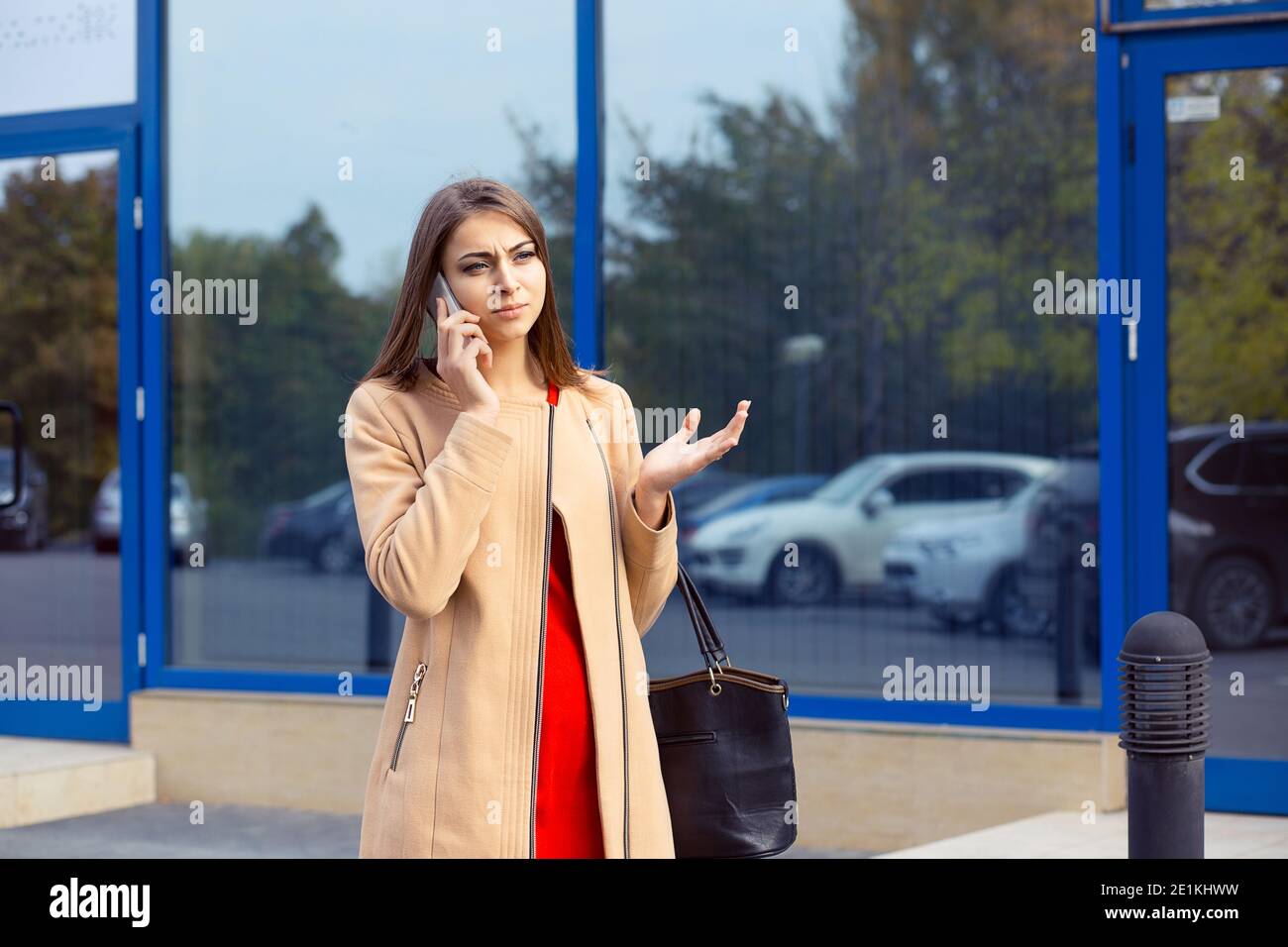Closeup portrait upset sad, skeptical, unhappy, serious woman talking on phone displeased with conversation isolated outdoors background. Negative hum Stock Photo
