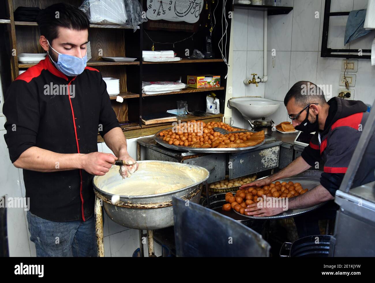 Damascus, Syria. 7th Jan, 2021. Sweet makers make Luqmat al-Qadi sweets, a traditional pastry made of leavened and deep fried dough, in Damascus, Syria, Jan. 7, 2021. Credit: Ammar Safarjalani/Xinhua/Alamy Live News Stock Photo