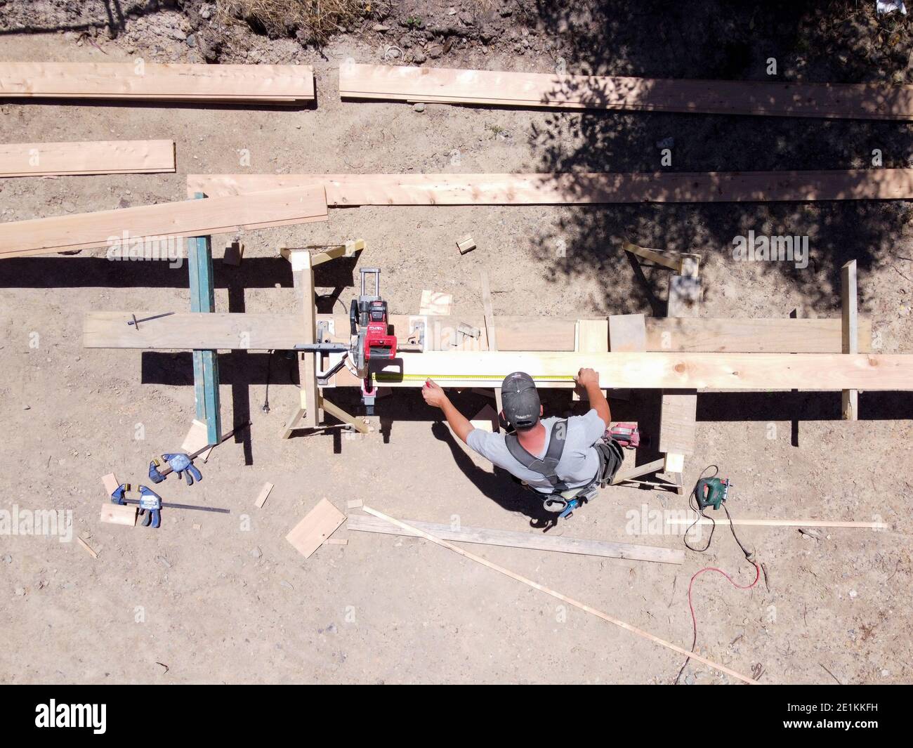 Overhead view of a carpenter working outside using a circular saw to trim wood Stock Photo