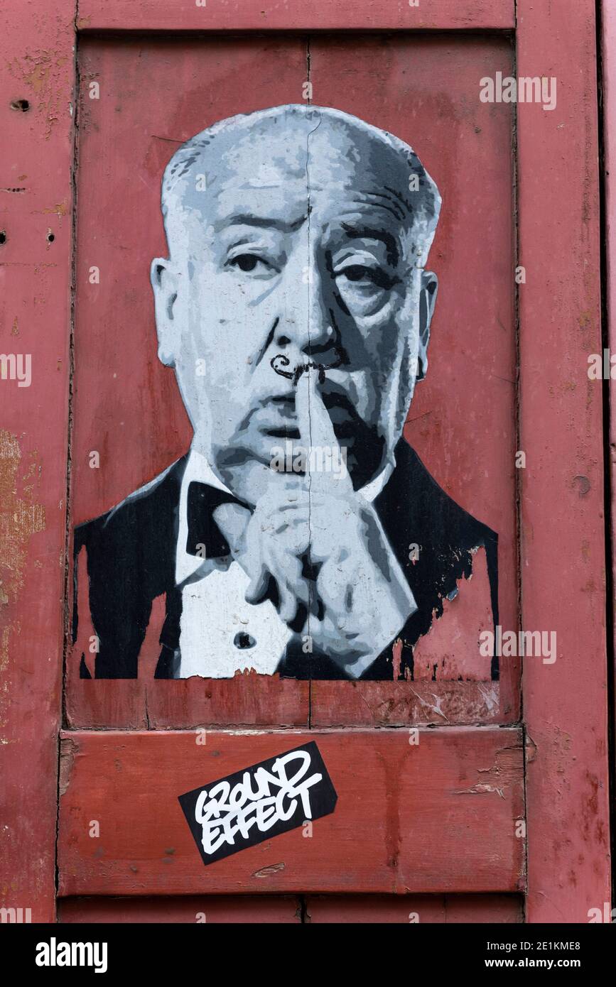 London,England:24 May,2017.  A rundown house in Princelet St is covered with artworks while the paint peels off around them. A poster of Alfred Hitchc Stock Photo