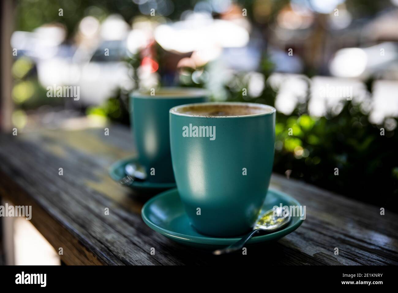 Shallow depth of field image of two green coffee mugs filled with cappuccino Stock Photo