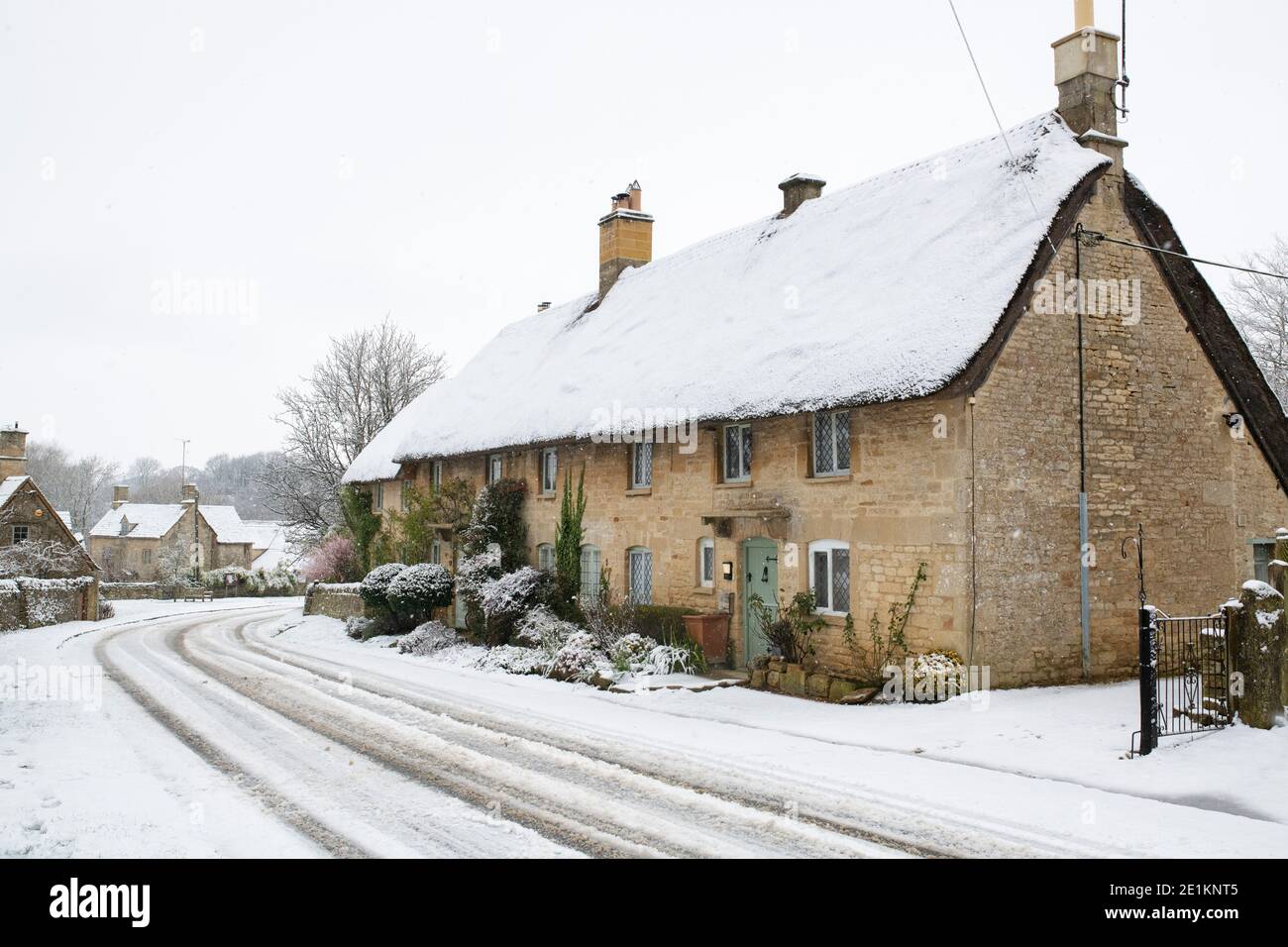 Cotswold stone thatched cottages in the snow at Christmas. Taynton