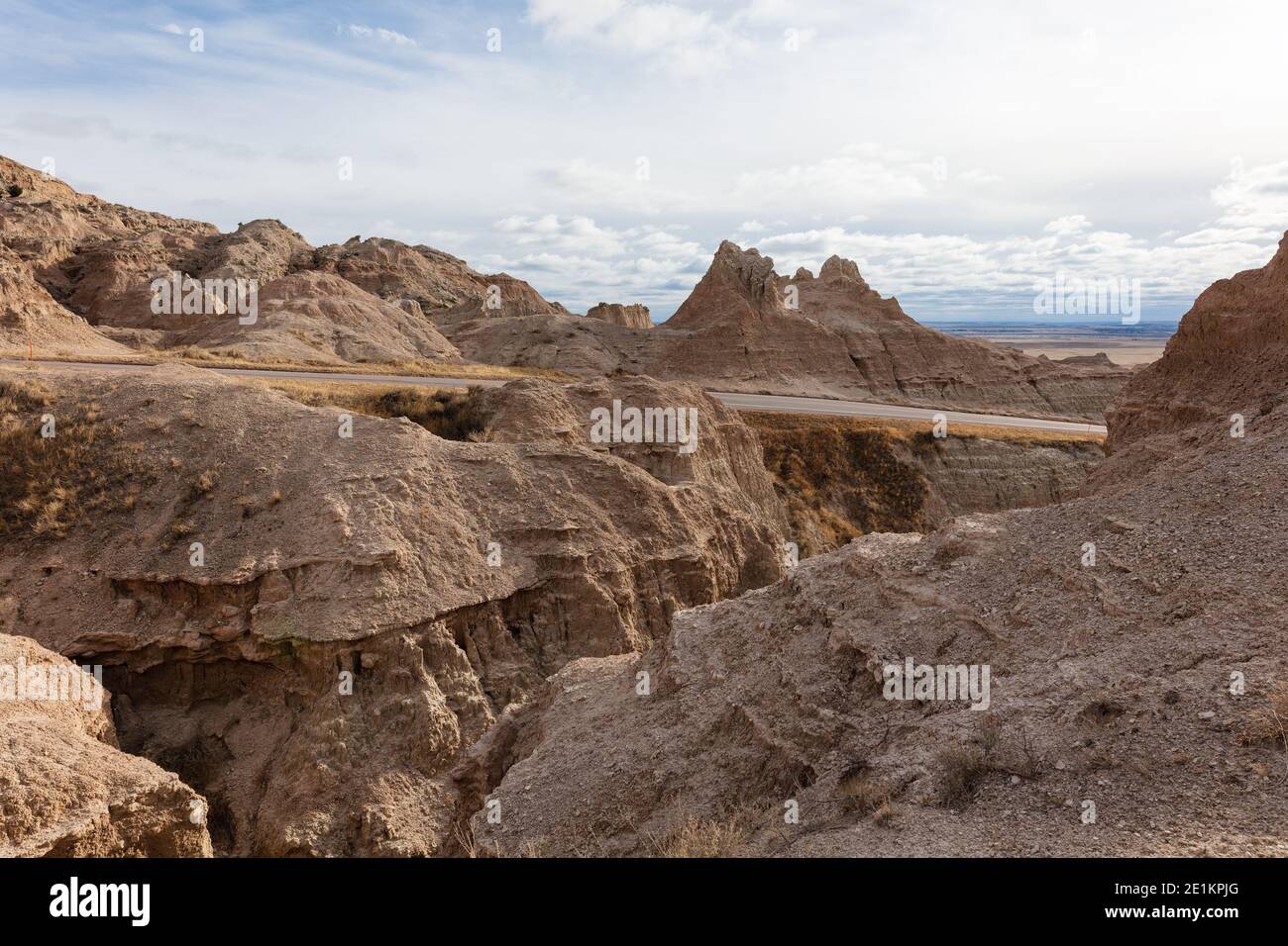 Road through rugged terrain and eroded landscape in Badlands National Park, South Dakota Stock Photo