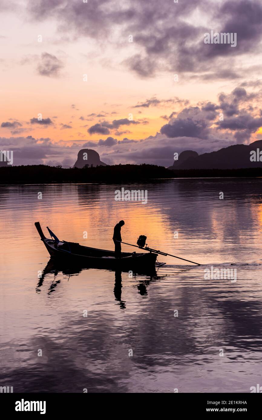 silhouette fisherman in fishing boat on sea at sunrise Stock Photo - Alamy