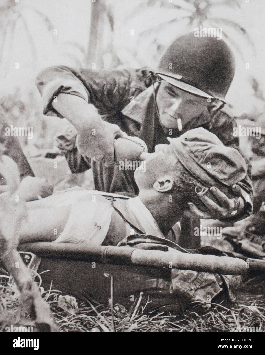 First aid to a wounded man on the battlefield. The infantry of the American Navy has just reconquered the island of Guam (The Second Battle of Guam. Stock Photo