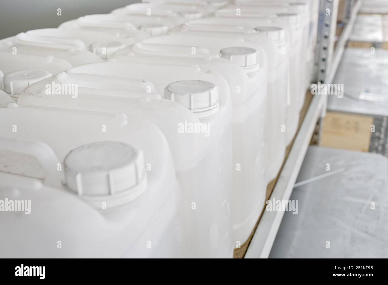 A lot of white plastic cans are lined up on the shelves of the